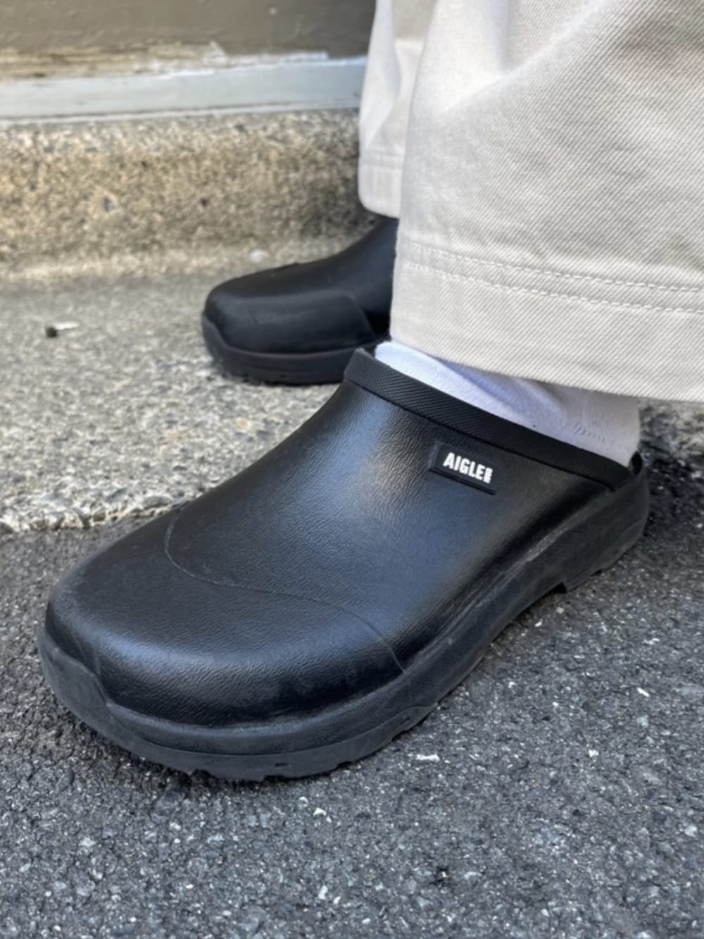 ベージュ系のマウンテンパーカー、ホワイト系のその他パンツ、ブラック系のサンダルを着用したレディースの春コーディネートの3枚目の写真