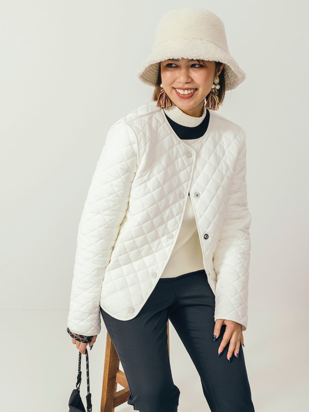 ブラック系のレインシューズ、ブラック系のショルダーバッグ、ブラック系のその他パンツを着用したレディースの冬コーディネートの2枚目の写真