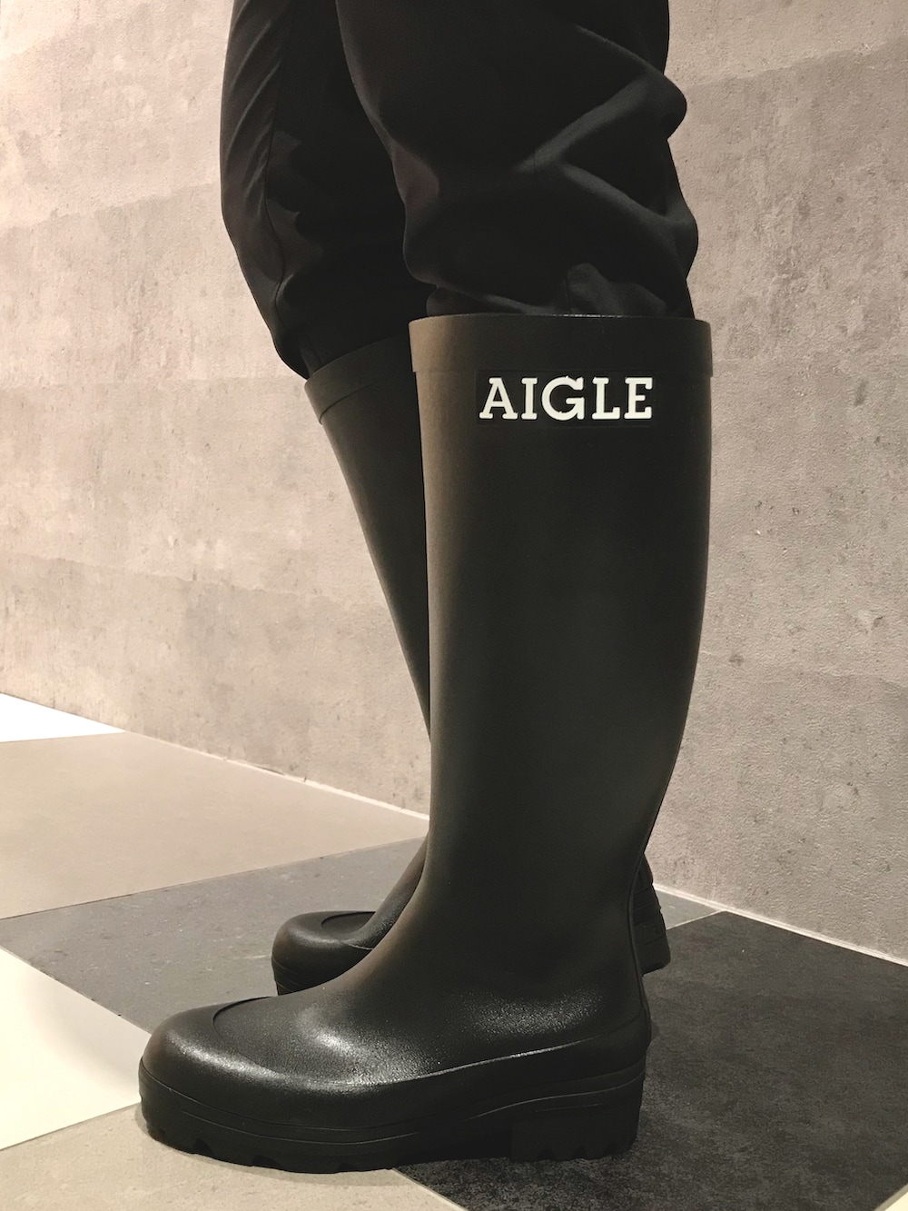 ホワイト系のマウンテンパーカー、グリーン系のバックパック/リュック、ブラック系のブーツを着用したレディースの春コーディネートの5枚目の写真