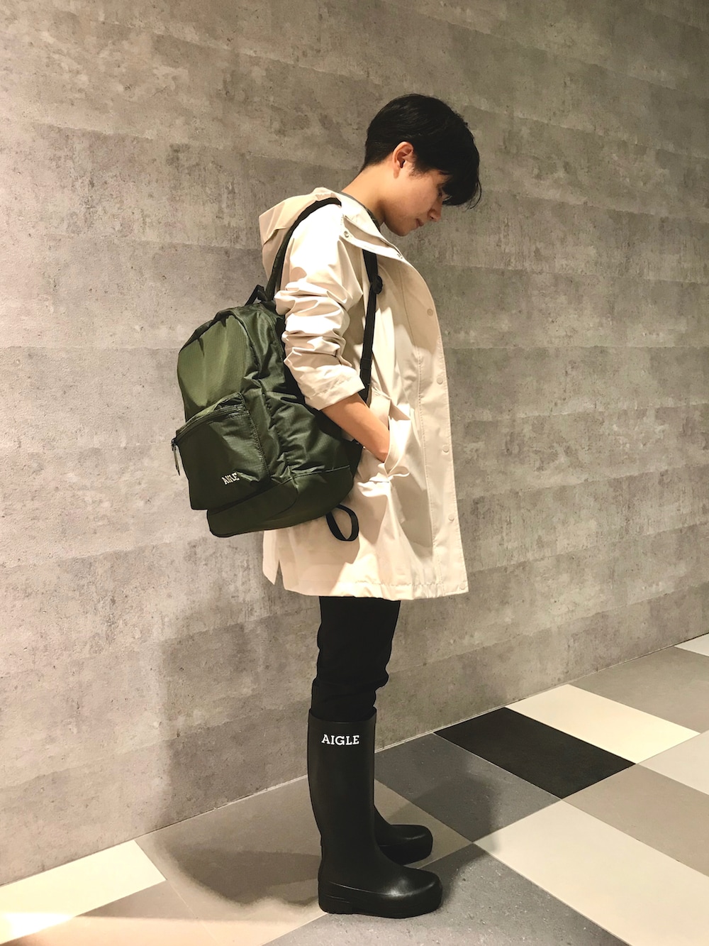 ホワイト系のマウンテンパーカー、グリーン系のバックパック/リュック、ブラック系のブーツを着用したレディースの春コーディネートの3枚目の写真