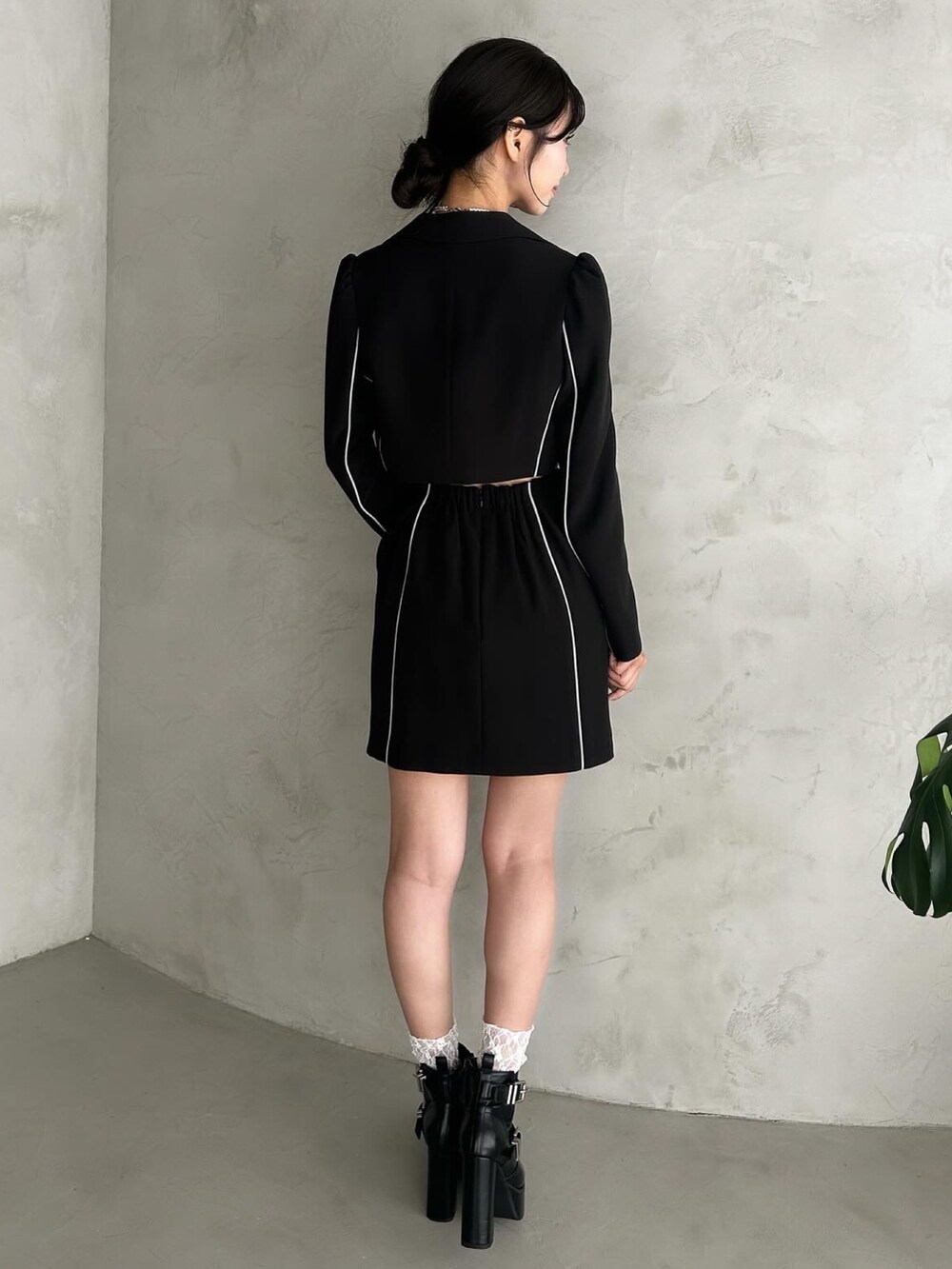 ブラック系のテーラードジャケット、ブラック系のキャミソール、ブラック系のスカートを着用したレディースの秋コーディネートの5枚目の写真