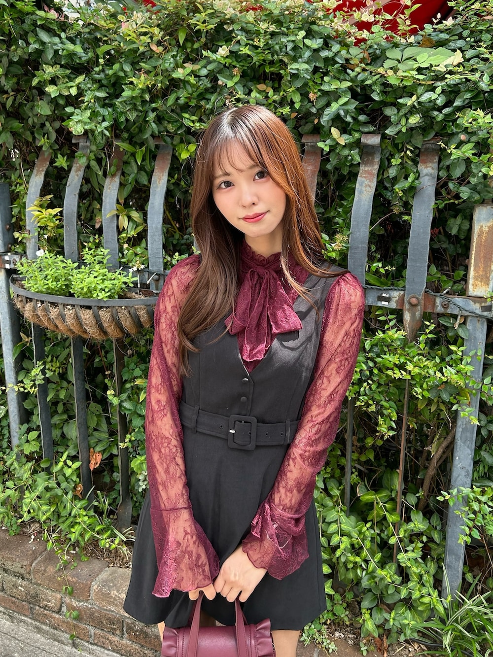 ブラック系のジャンパースカート、レッド系のパンプス、レッド系のシャツ/ブラウスを着用したレディースの夏コーディネートの4枚目の写真