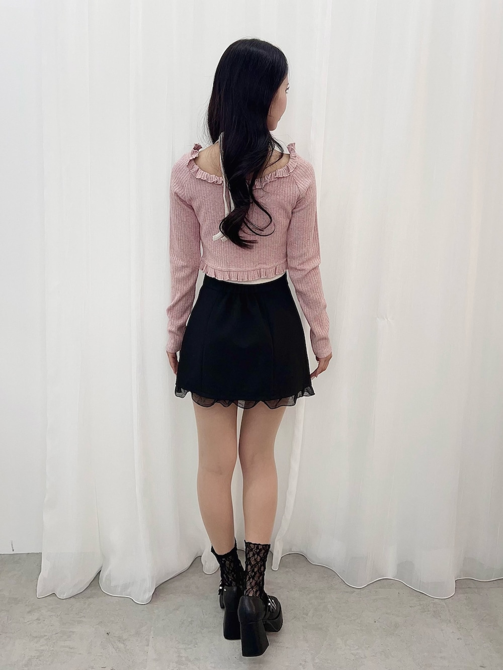 ピンク系のTシャツ/カットソー、ブラック系のスカート、ブラック系のパンプスを着用したレディースの冬コーディネートの3枚目の写真