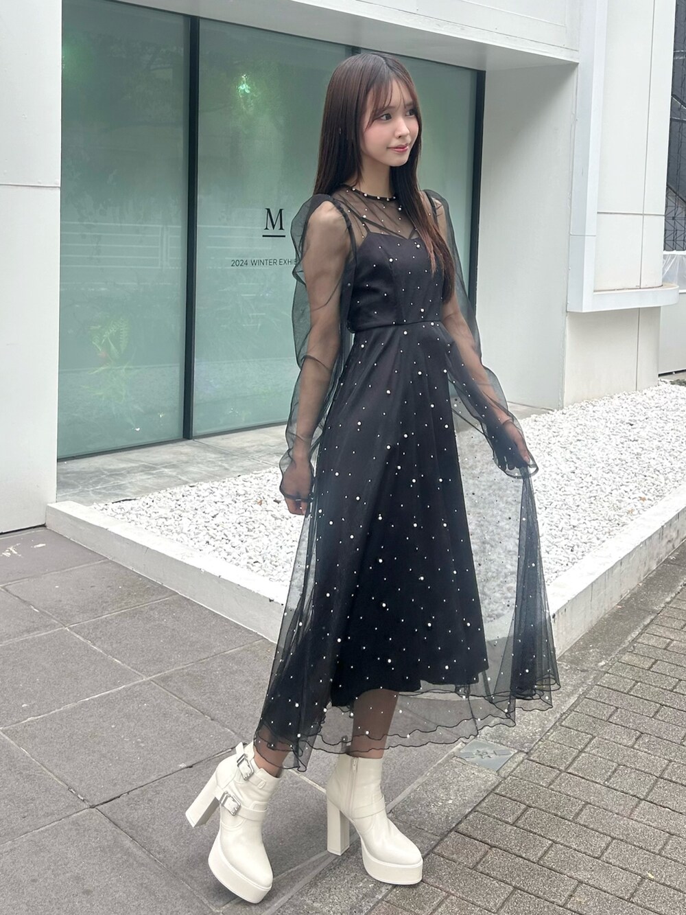 ブラック系のワンピース、ホワイト系のブーツを着用したレディースの秋コーディネートの2枚目の写真