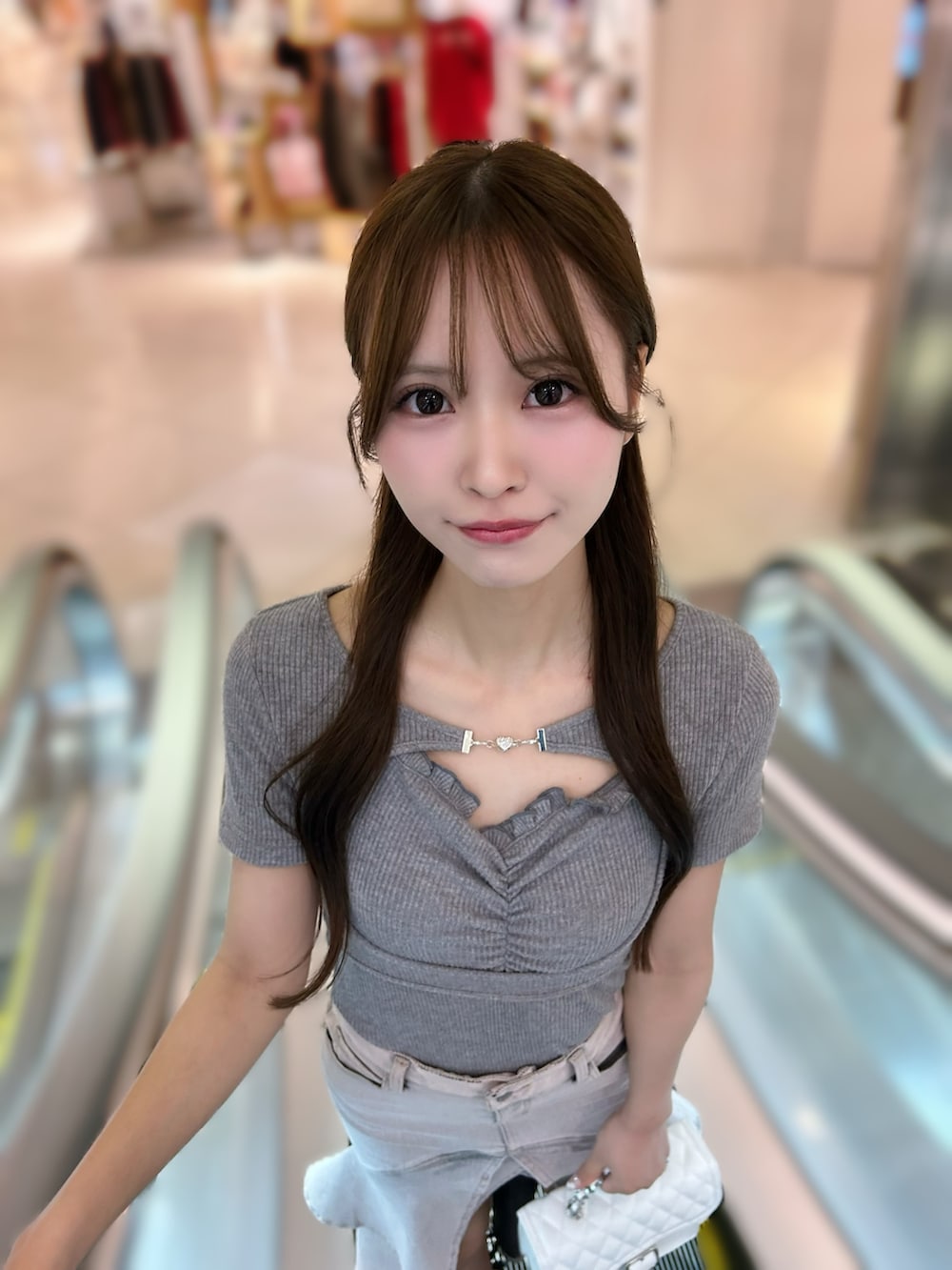 ピンク系のデニムスカート、グレー系のTシャツ/カットソー、ブラック系のサンダルを着用したレディースの秋コーディネートの7枚目の写真