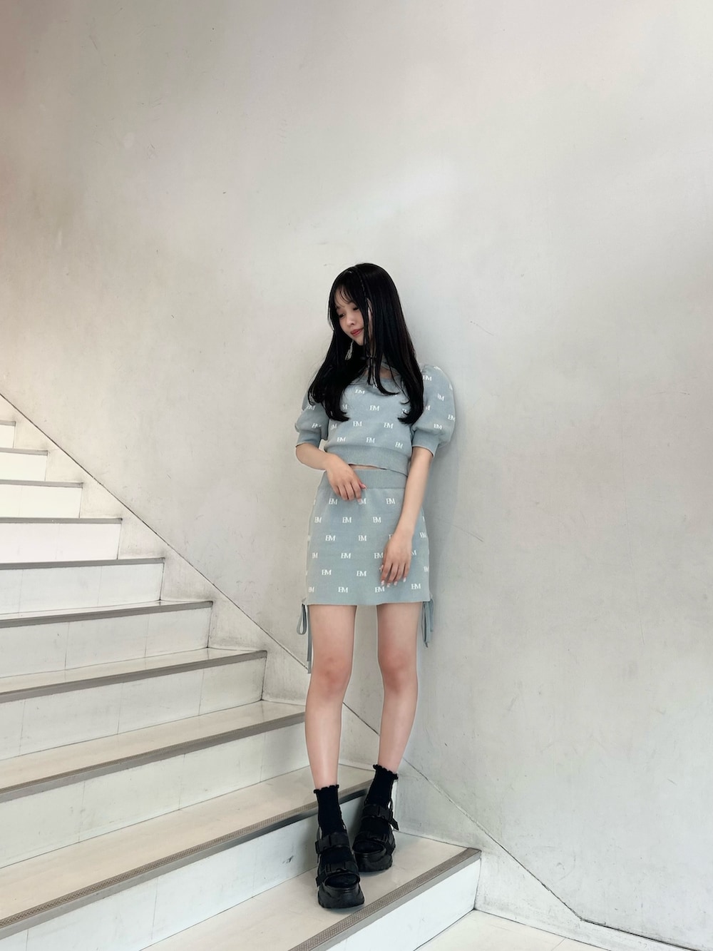 グリーン系のニット/セーター、グリーン系のスカート、ブラック系のサンダルを着用したレディースの春コーディネートの2枚目の写真