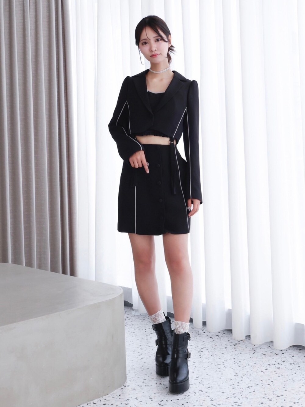 ブラック系のテーラードジャケット、ブラック系のキャミソール、ブラック系のスカートを着用したレディースの秋コーディネートの2枚目の写真