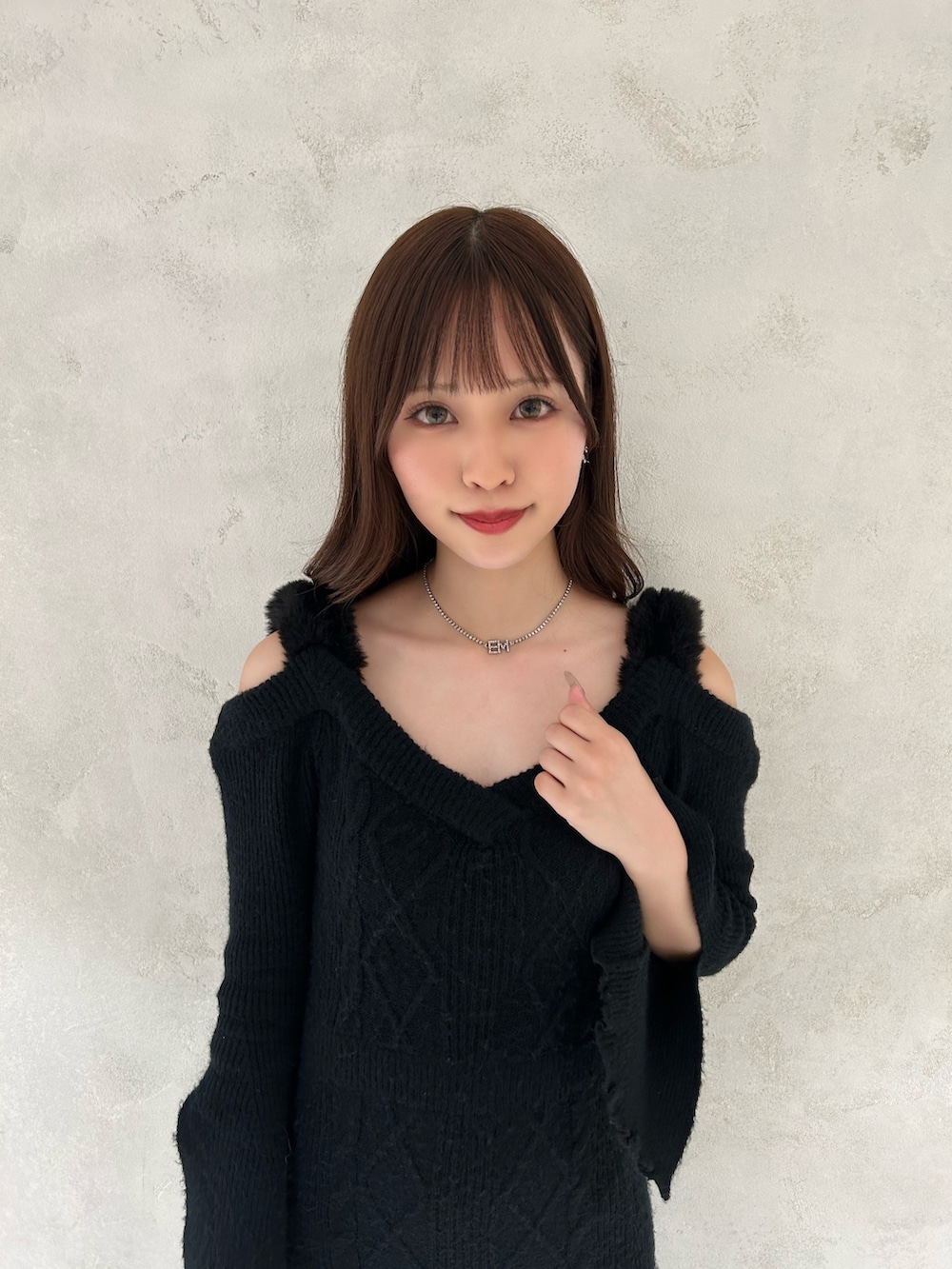 ブラック系のワンピース、ブラック系のブーツ、シルバー系のピアス（両耳用）を着用したレディースの秋コーディネートの4枚目の写真