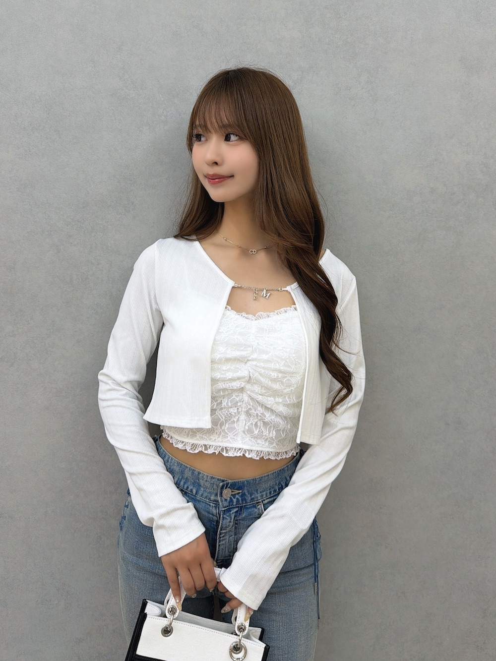 ブルー系のデニムパンツ、ホワイト系のサンダル、ホワイト系のショルダーバッグを着用したレディースの春コーディネートの6枚目の写真