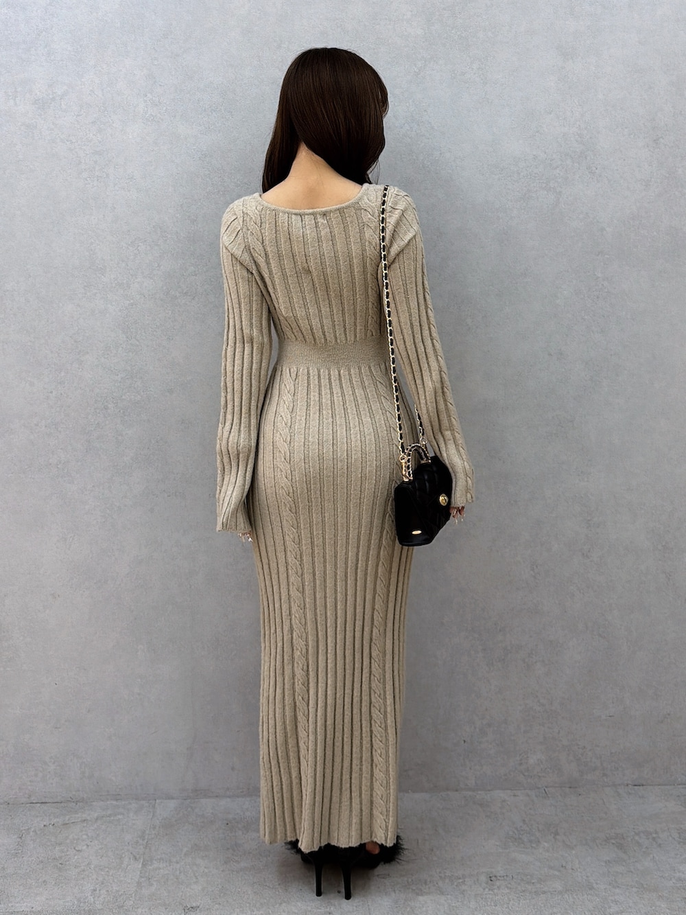 ベージュ系のワンピース、ブラック系のハンドバッグ、ブラック系のサンダルを着用したレディースの冬コーディネートの4枚目の写真