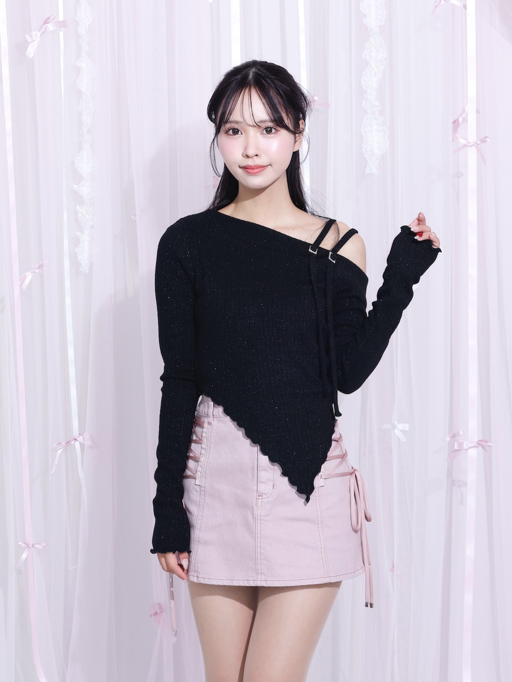 ピンク系のデニムスカート、ブラック系のTシャツ/カットソー、ブラック系のサンダルを着用したレディースの冬コーディネートの2枚目の写真