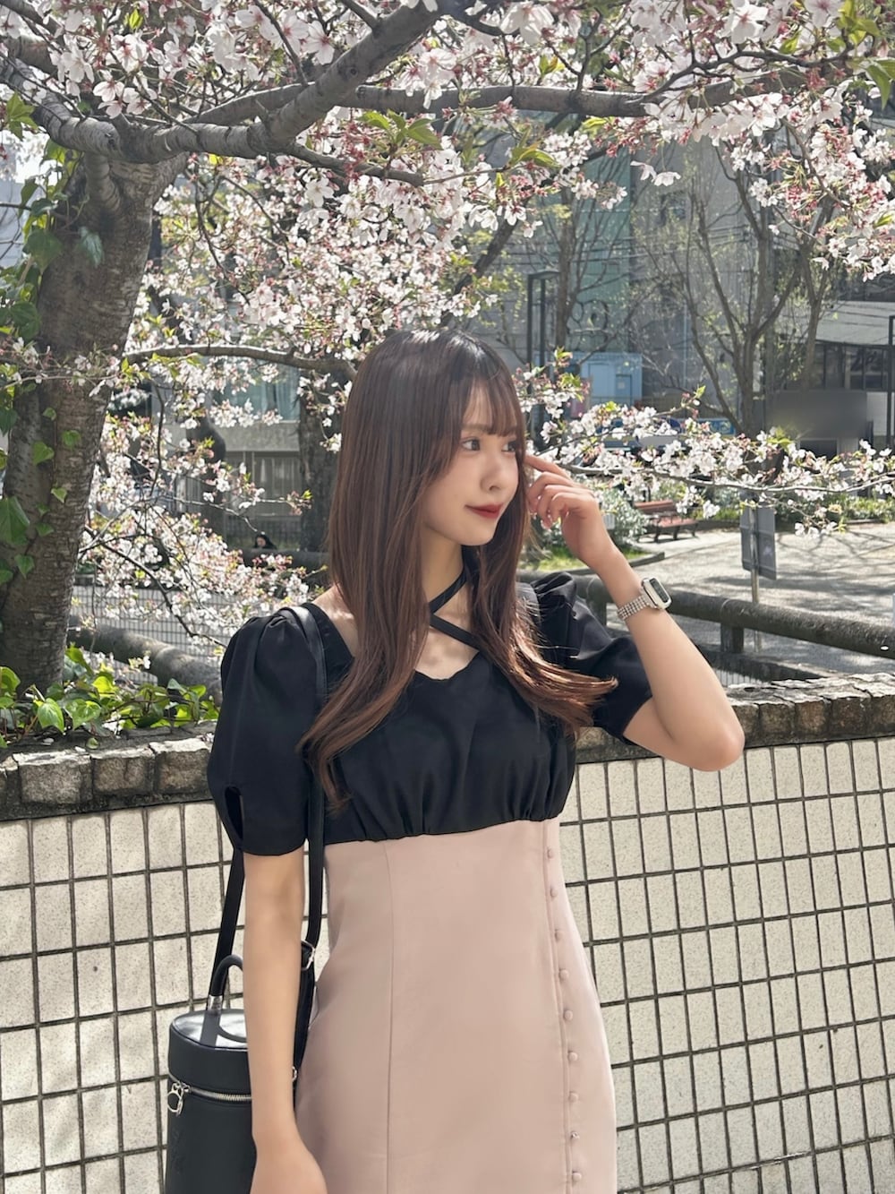 ピンク系のワンピース、ブラック系のサンダル、ブラック系のハンドバッグを着用したレディースの春コーディネートの4枚目の写真