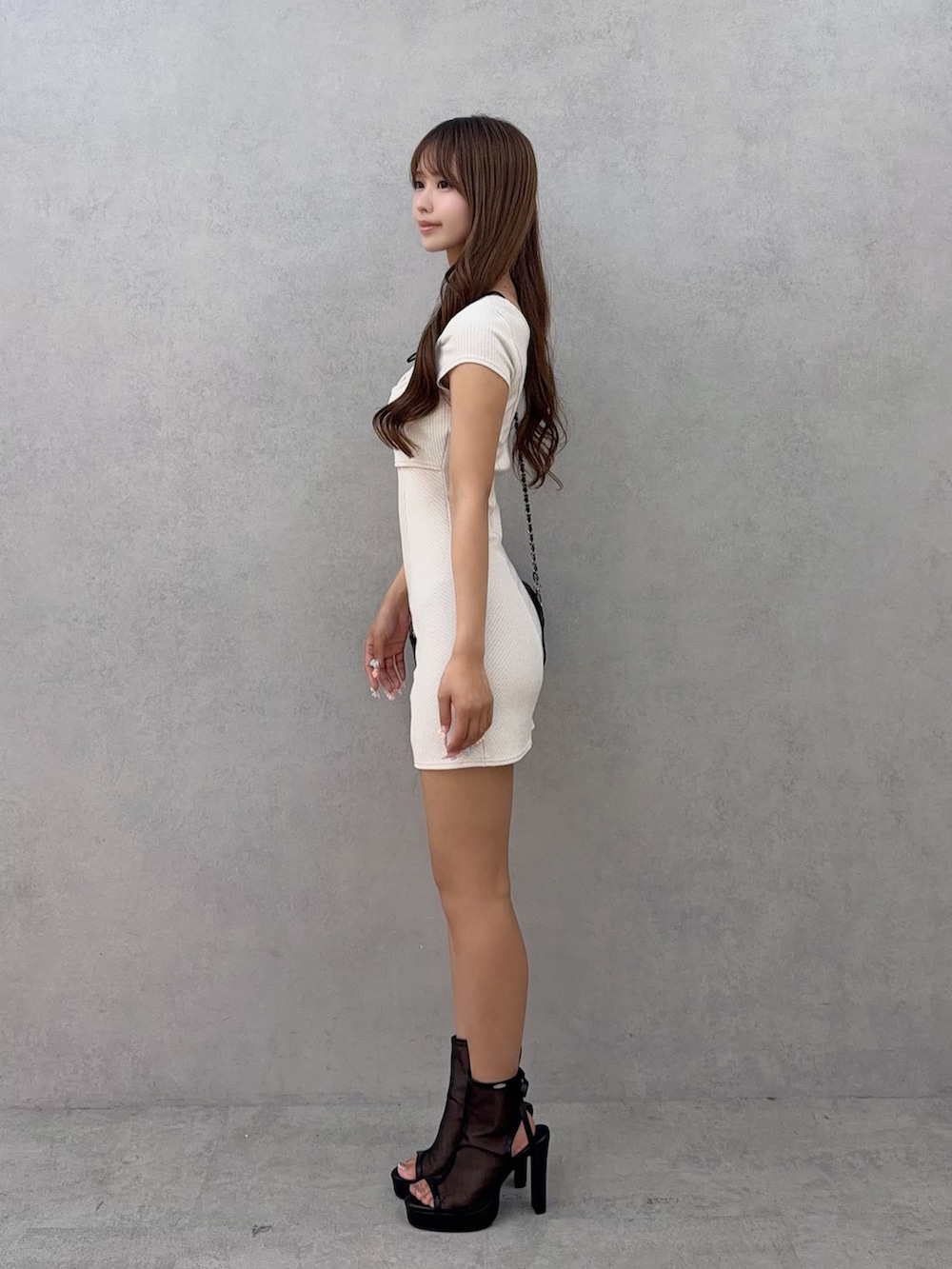 ホワイト系のワンピース、ブラック系のサンダルを着用したレディースの夏コーディネートの3枚目の写真