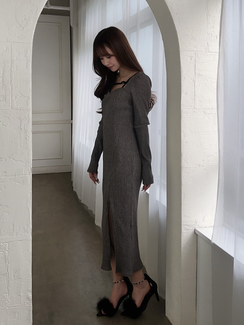 グレー系のワンピース、ブラック系のサンダルを着用したレディースの冬コーディネートの3枚目の写真