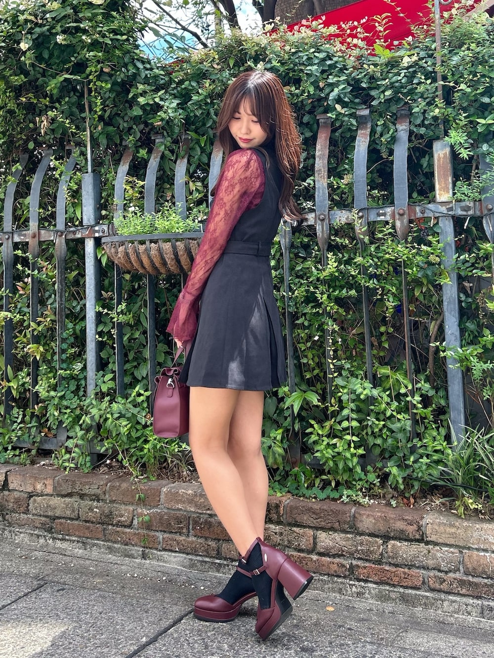 ブラック系のジャンパースカート、レッド系のパンプス、レッド系のシャツ/ブラウスを着用したレディースの夏コーディネートの3枚目の写真