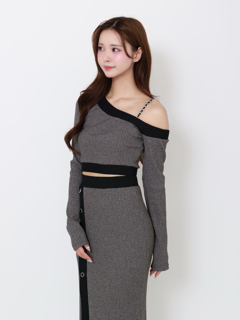 グレー系のTシャツ/カットソー、グレー系のスカート、ブラック系のブーツを着用したレディースの冬コーディネートの4枚目の写真