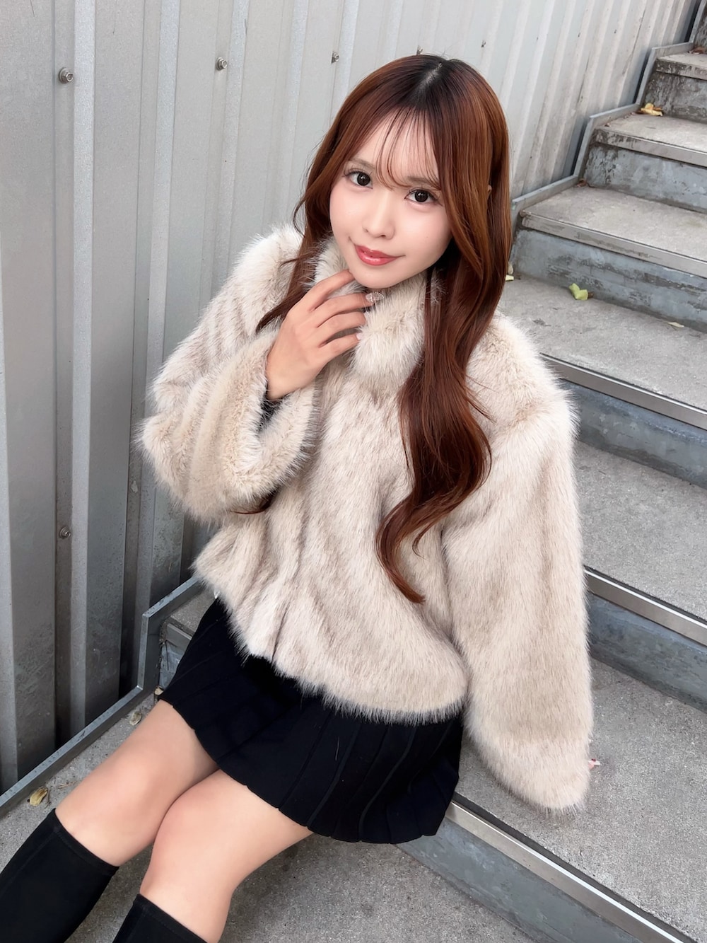 ベージュ系のブルゾン、ブラック系のワンピース、ブラック系のブーツを着用したレディースの冬コーディネートの6枚目の写真