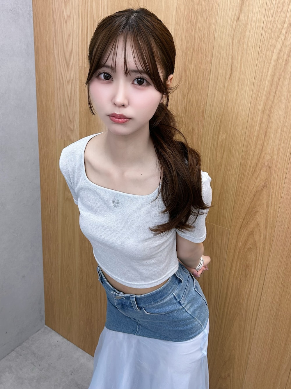 シルバー系のTシャツ/カットソー、ブルー系のデニムスカート、ホワイト系のサンダルを着用したレディースの夏コーディネートの4枚目の写真