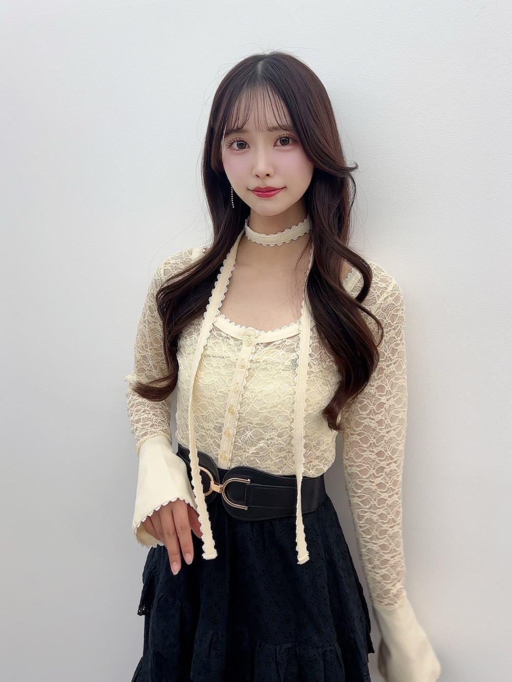イエロー系のTシャツ/カットソー、ブラック系のスカート、ホワイト系のサンダルを着用したレディースの春コーディネートの5枚目の写真