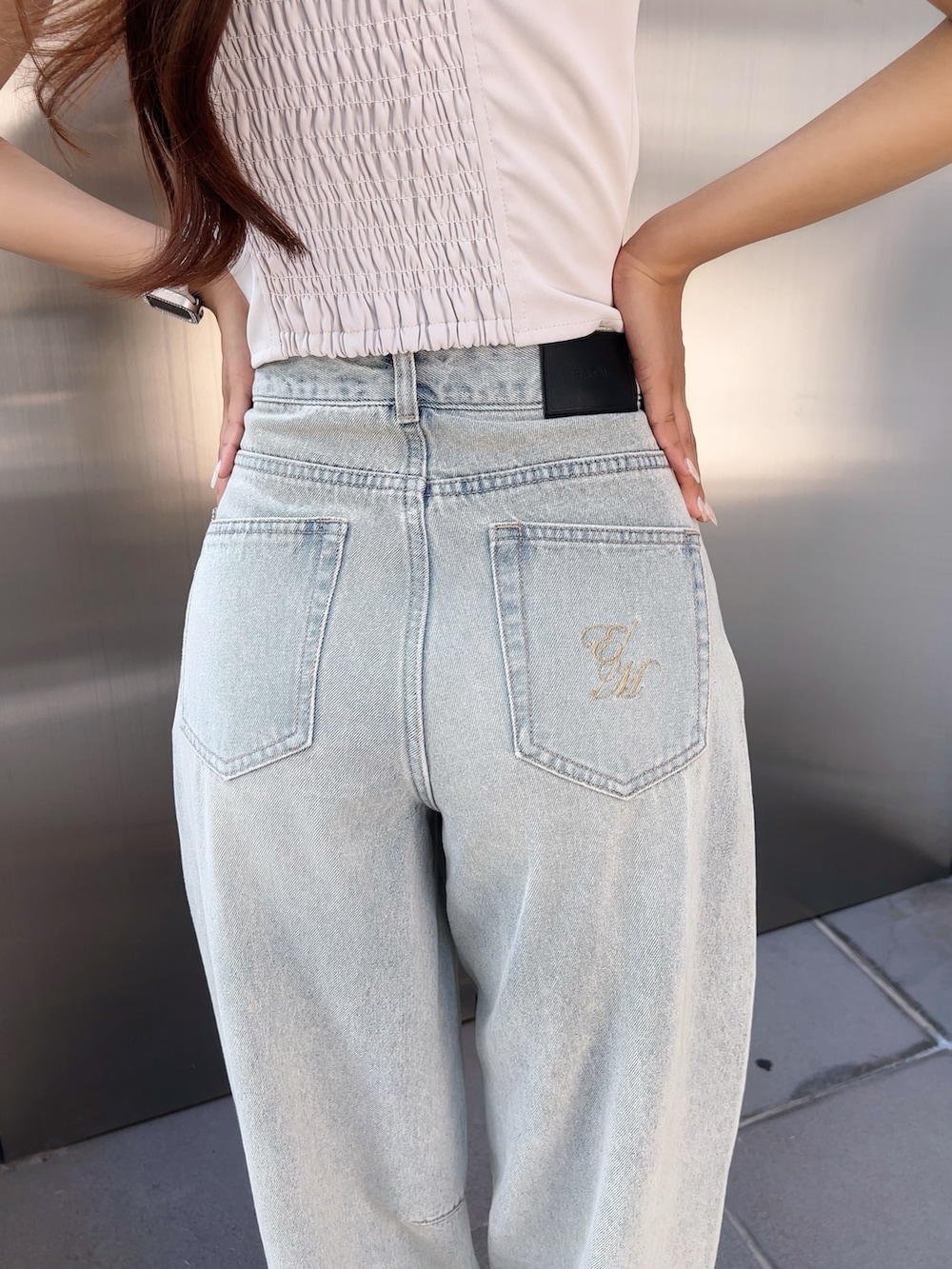 ホワイト系のキャミソール、ブルー系のデニムパンツ、ブラック系のパンプスを着用したレディースの夏コーディネートの6枚目の写真