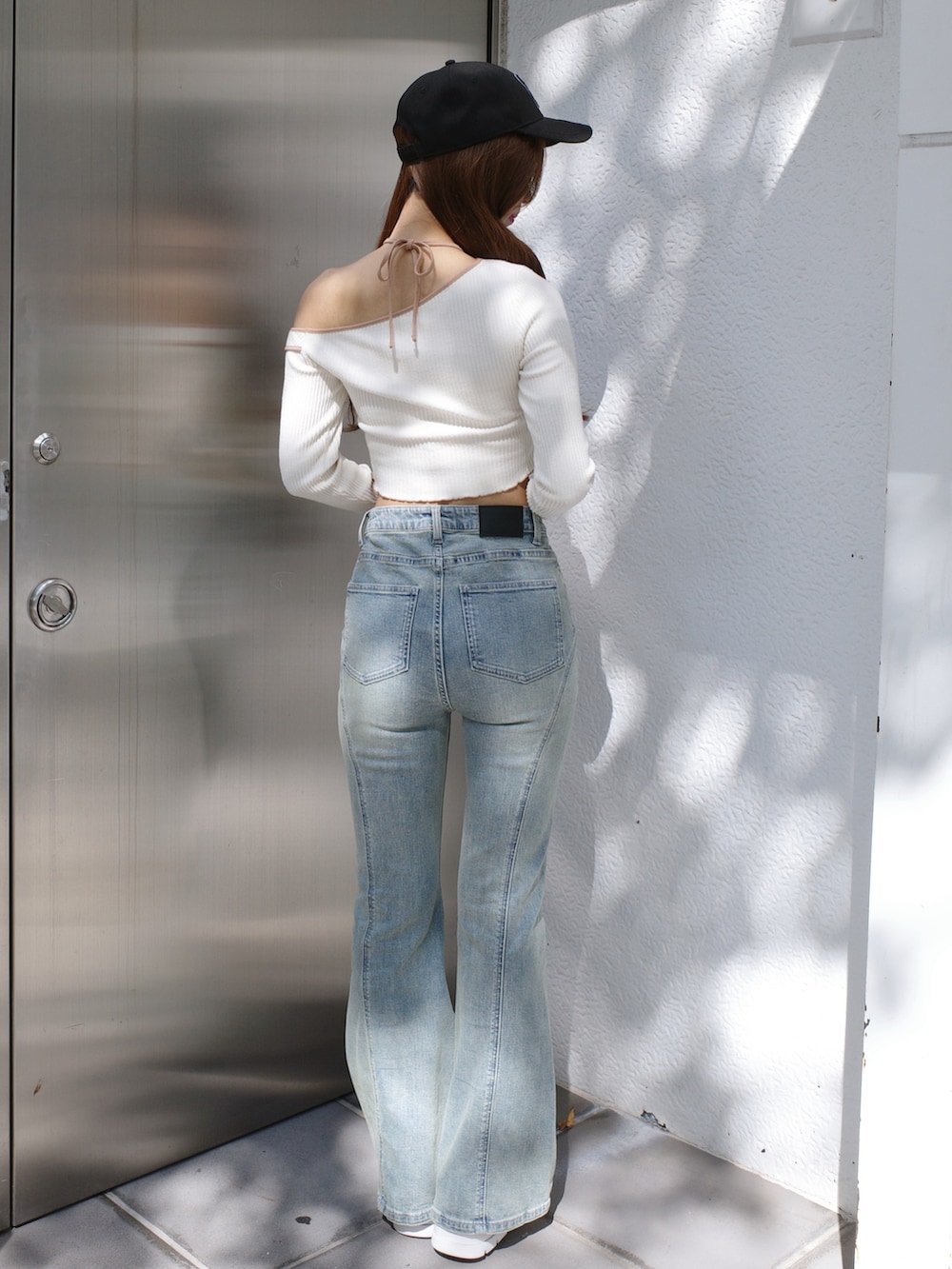 ブルー系のデニムパンツ、ホワイト系のTシャツ/カットソー、ブラック系のキャップを着用したレディースの冬コーディネートの4枚目の写真