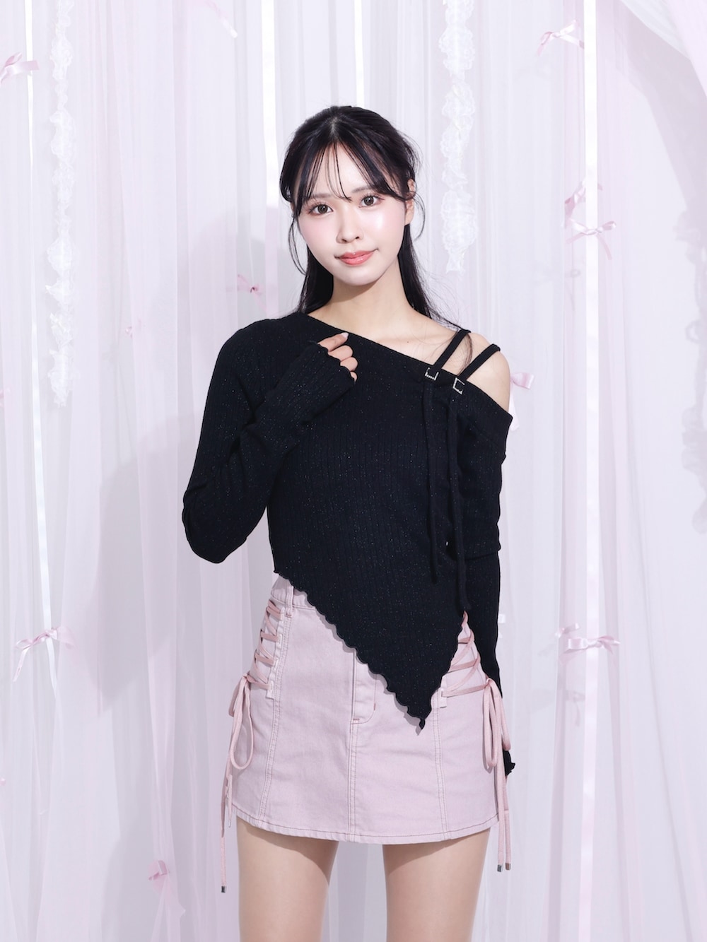 ピンク系のデニムスカート、ブラック系のTシャツ/カットソー、ブラック系のサンダルを着用したレディースの冬コーディネートの3枚目の写真