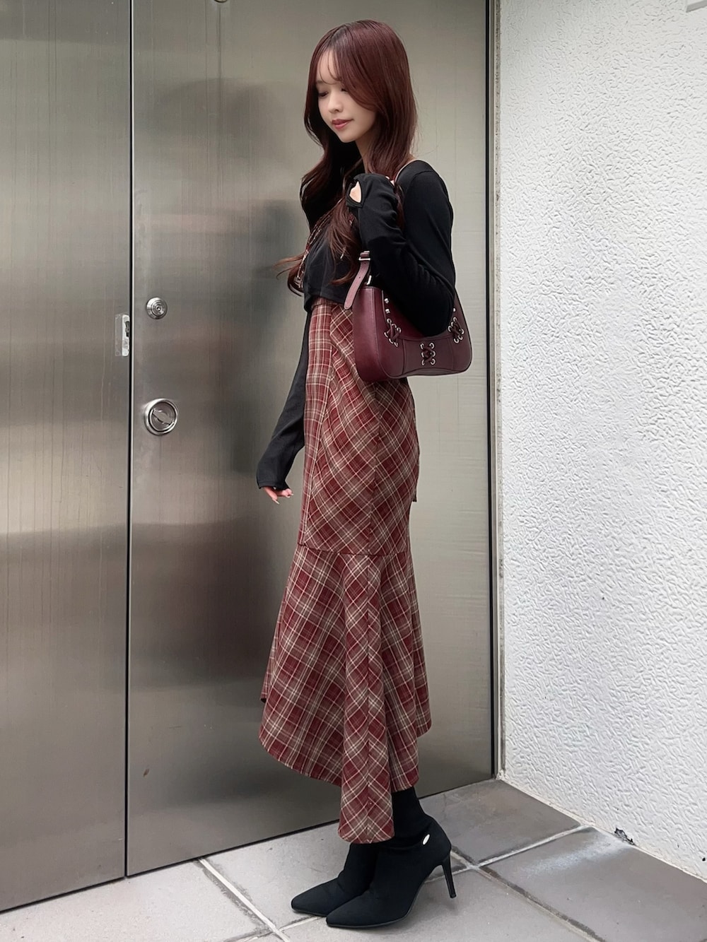 レッド系のワンピース、ブラック系のブーツ、レッド系のショルダーバッグを着用したレディースの秋コーディネートの2枚目の写真