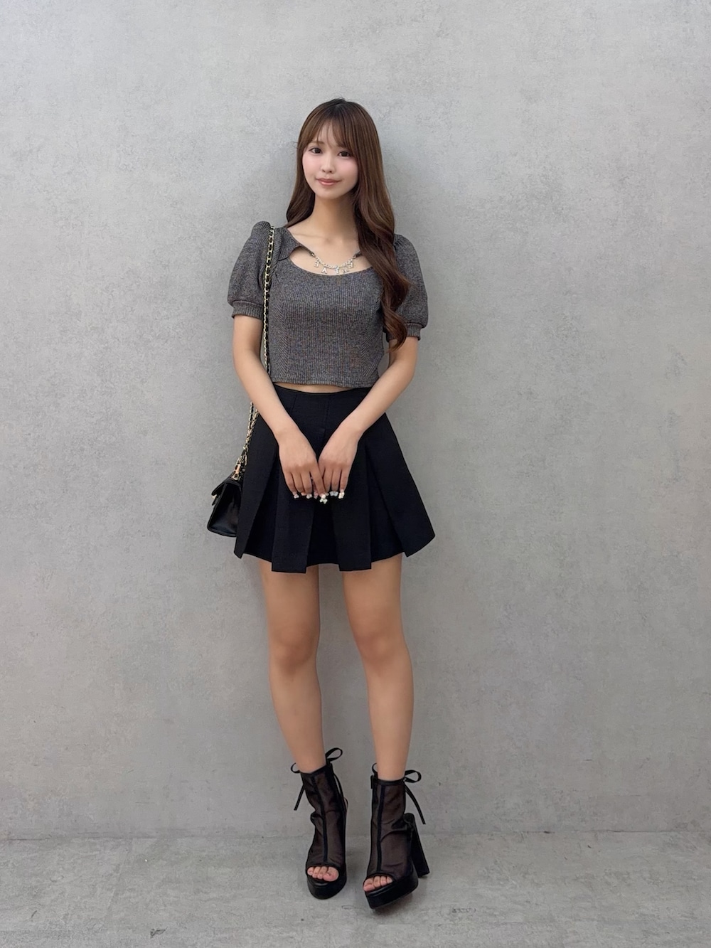 ブラック系のスカート、グレー系のTシャツ/カットソー、ブラック系のサンダルを着用したレディースの夏コーディネートの2枚目の写真