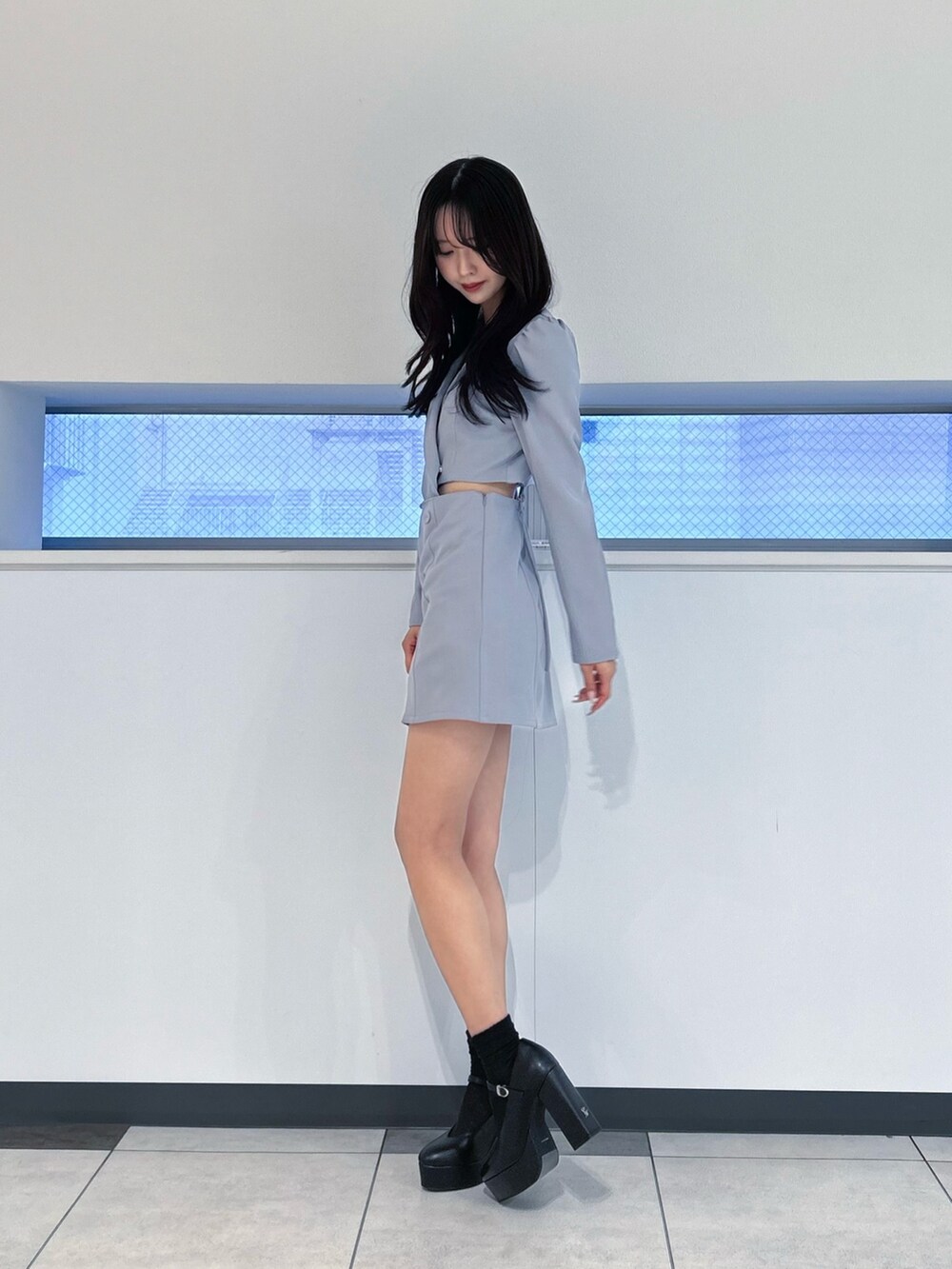 ブルー系のワンピース、ブラック系のパンプス、シルバー系のネックレスを着用したレディースの冬コーディネートの3枚目の写真