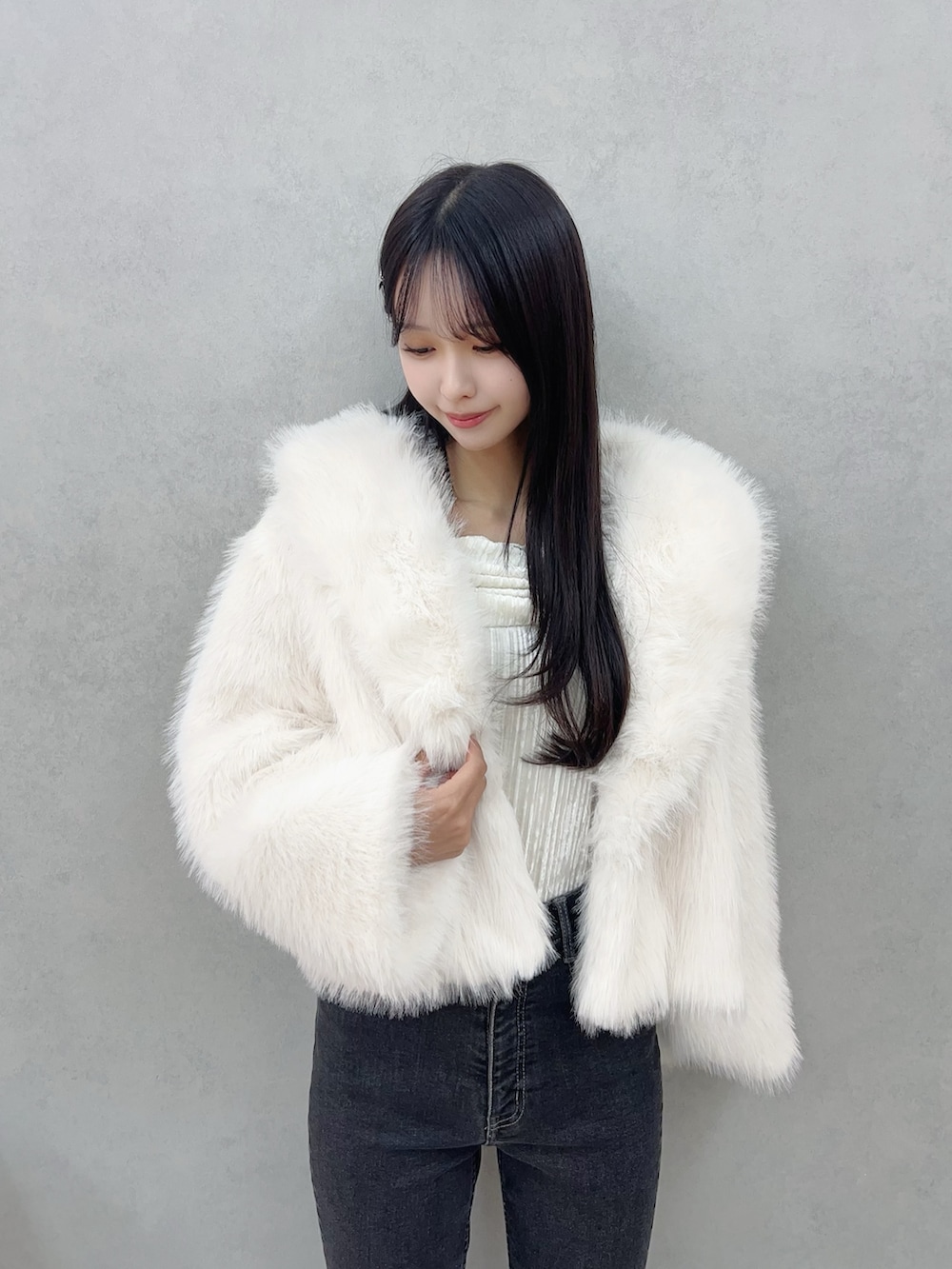 ホワイト系のその他アウター、ブラック系のデニムパンツ、ホワイト系のTシャツ/カットソーを着用したレディースの冬コーディネートの6枚目の写真