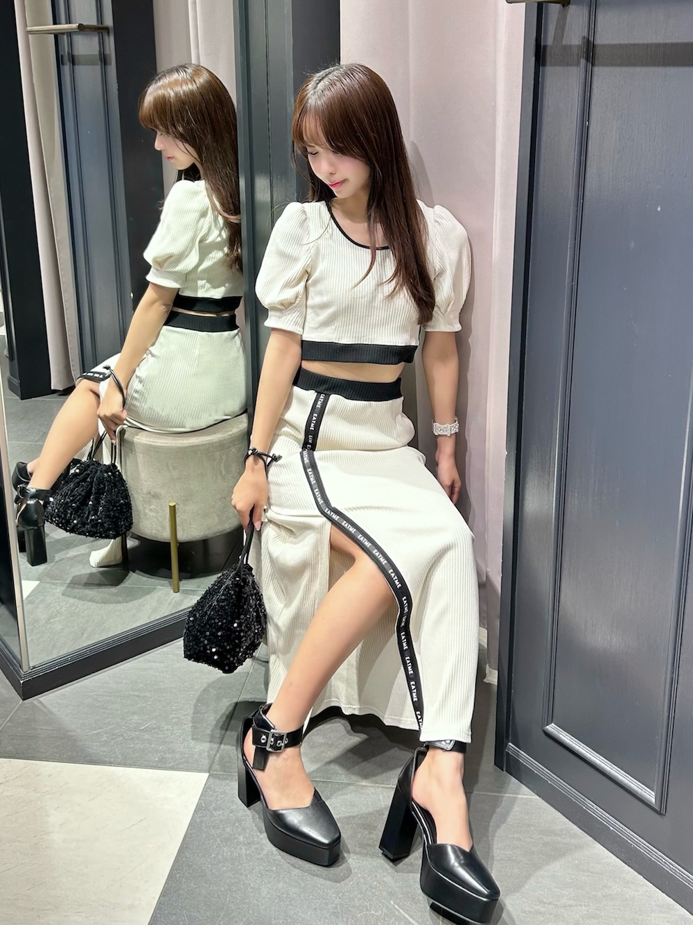 ホワイト系のTシャツ/カットソー、ホワイト系のスカート、ブラック系のハンドバッグを着用したレディースの夏コーディネートの4枚目の写真