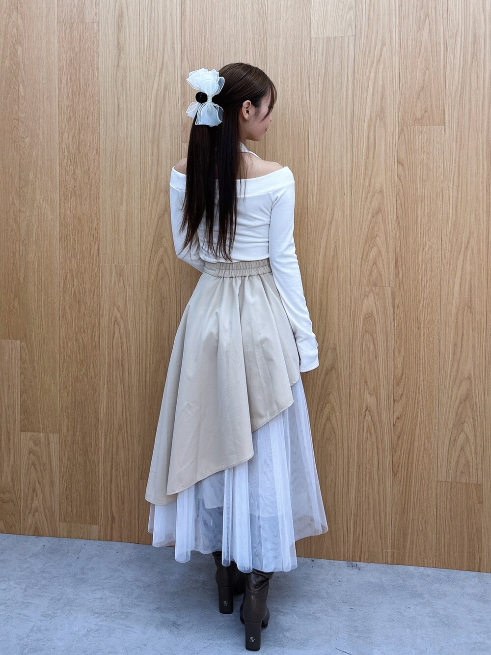 ベージュ系のスカート、ホワイト系のTシャツ/カットソー、ブラウン系のブーツを着用したレディースの秋コーディネートの4枚目の写真