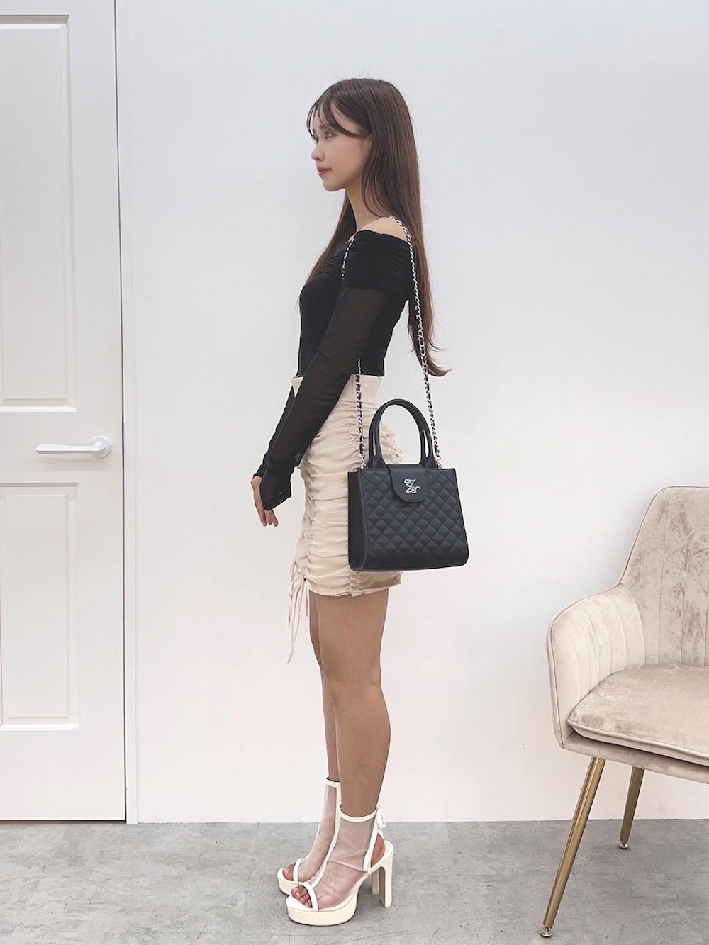 ホワイト系のスカート、ブラック系のTシャツ/カットソー、ホワイト系のサンダルを着用したレディースの春コーディネートの2枚目の写真