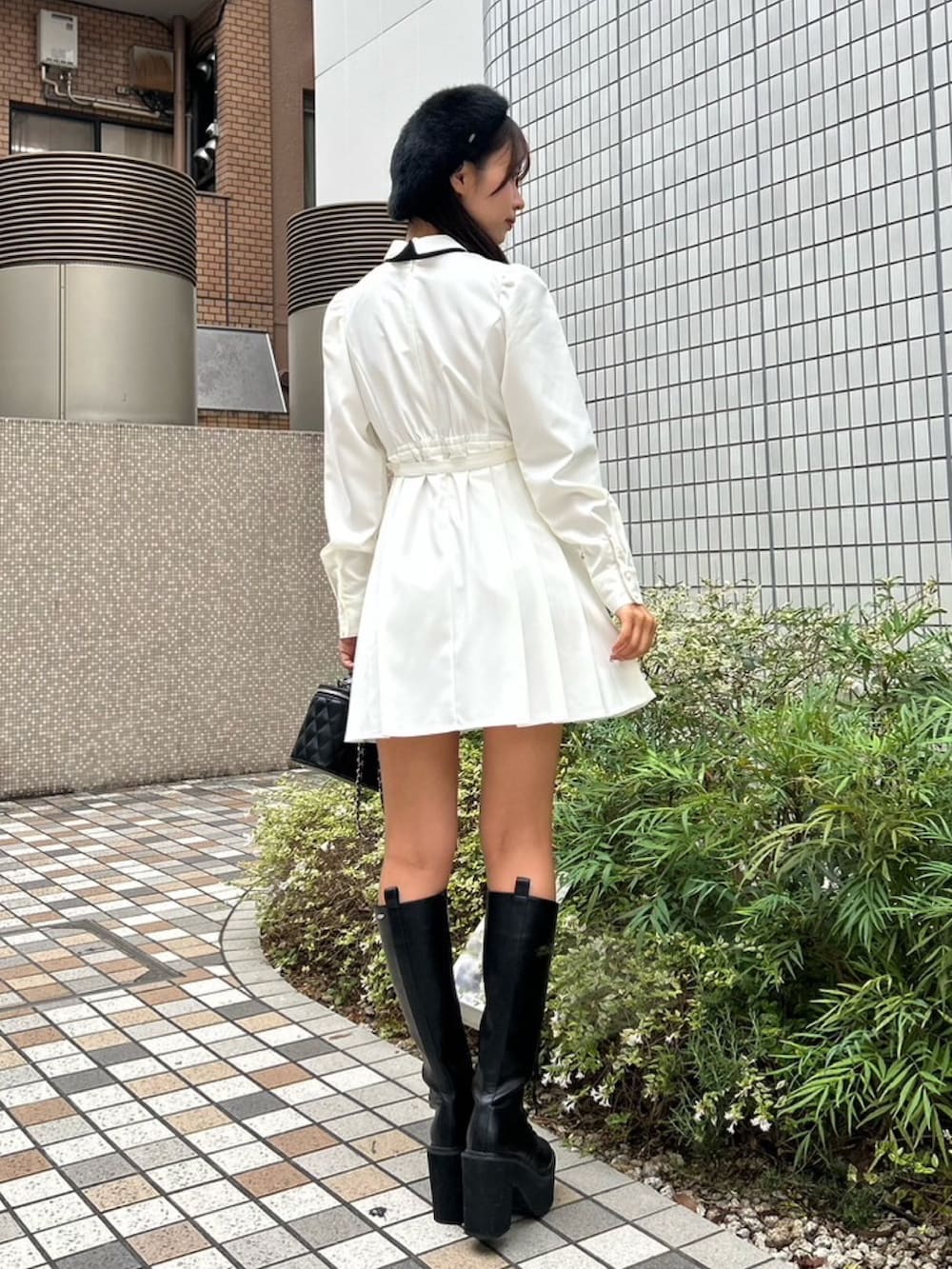 ホワイト系のワンピース、ブラック系のハンドバッグ、ブラック系のブーツを着用したレディースの秋コーディネートの3枚目の写真