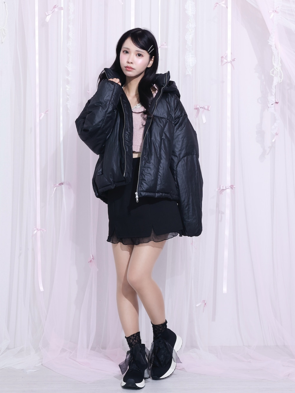 ブラック系のブルゾン、ピンク系のTシャツ/カットソー、ブラック系のスカートを着用したレディースの冬コーディネートの2枚目の写真