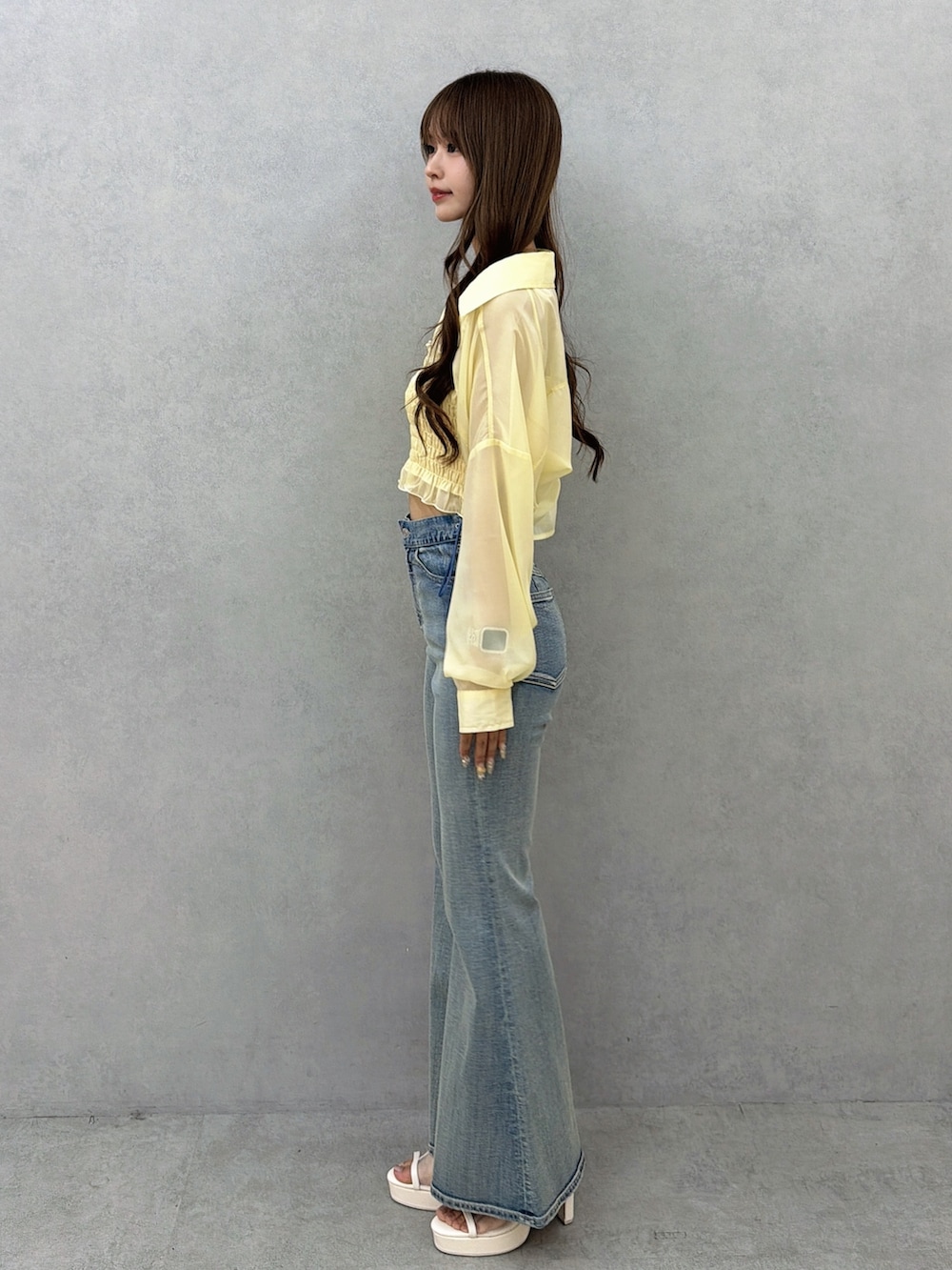 ブルー系のデニムパンツ、イエロー系のシャツ/ブラウス、ホワイト系のサンダルを着用したレディースの春コーディネートの3枚目の写真