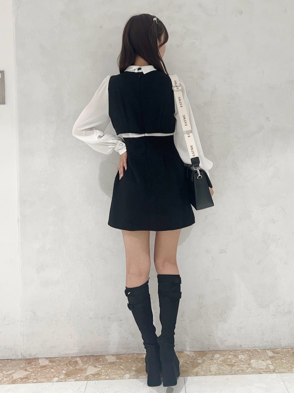 ブラック系のショルダーバッグ、ブラック系のワンピース、ブラック系のブーツを着用したレディースの秋コーディネートの3枚目の写真