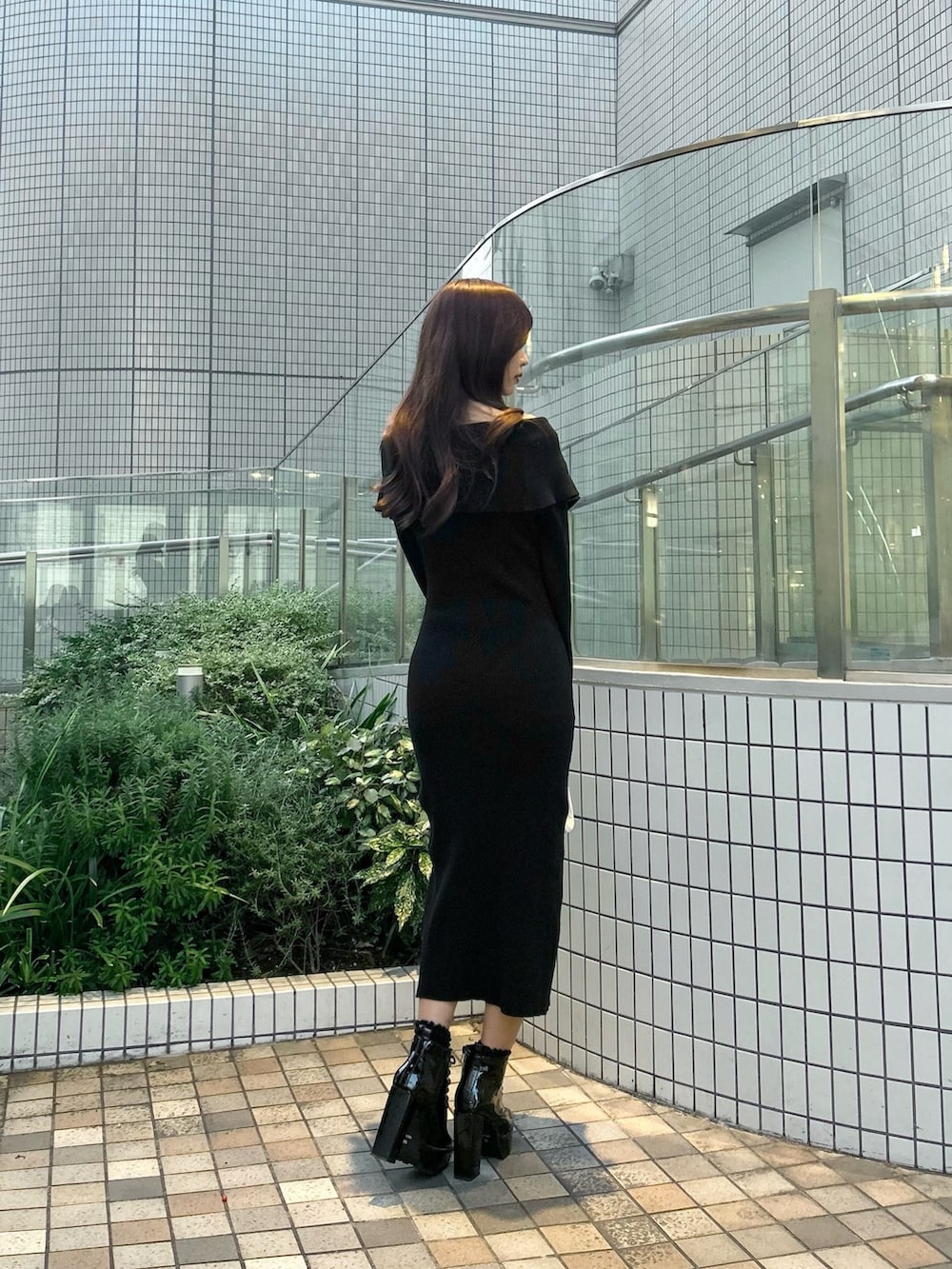 ブラック系のワンピース、ホワイト系のショルダーバッグ、その他のブーツを着用したレディースの秋コーディネートの4枚目の写真