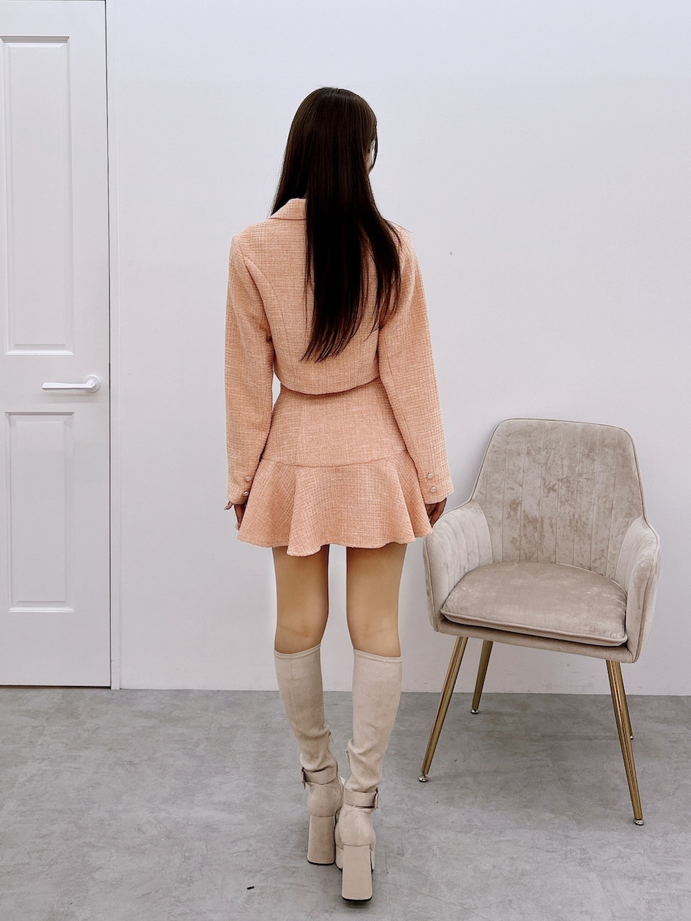 オレンジ系のスカート、オレンジ系のテーラードジャケット、ホワイト系のブーツを着用したレディースの秋コーディネートの3枚目の写真