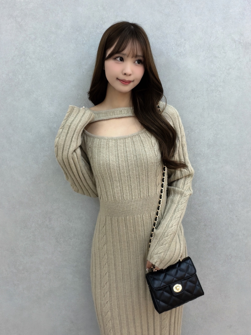 ベージュ系のワンピース、ブラック系のハンドバッグ、ブラック系のサンダルを着用したレディースの冬コーディネートの6枚目の写真