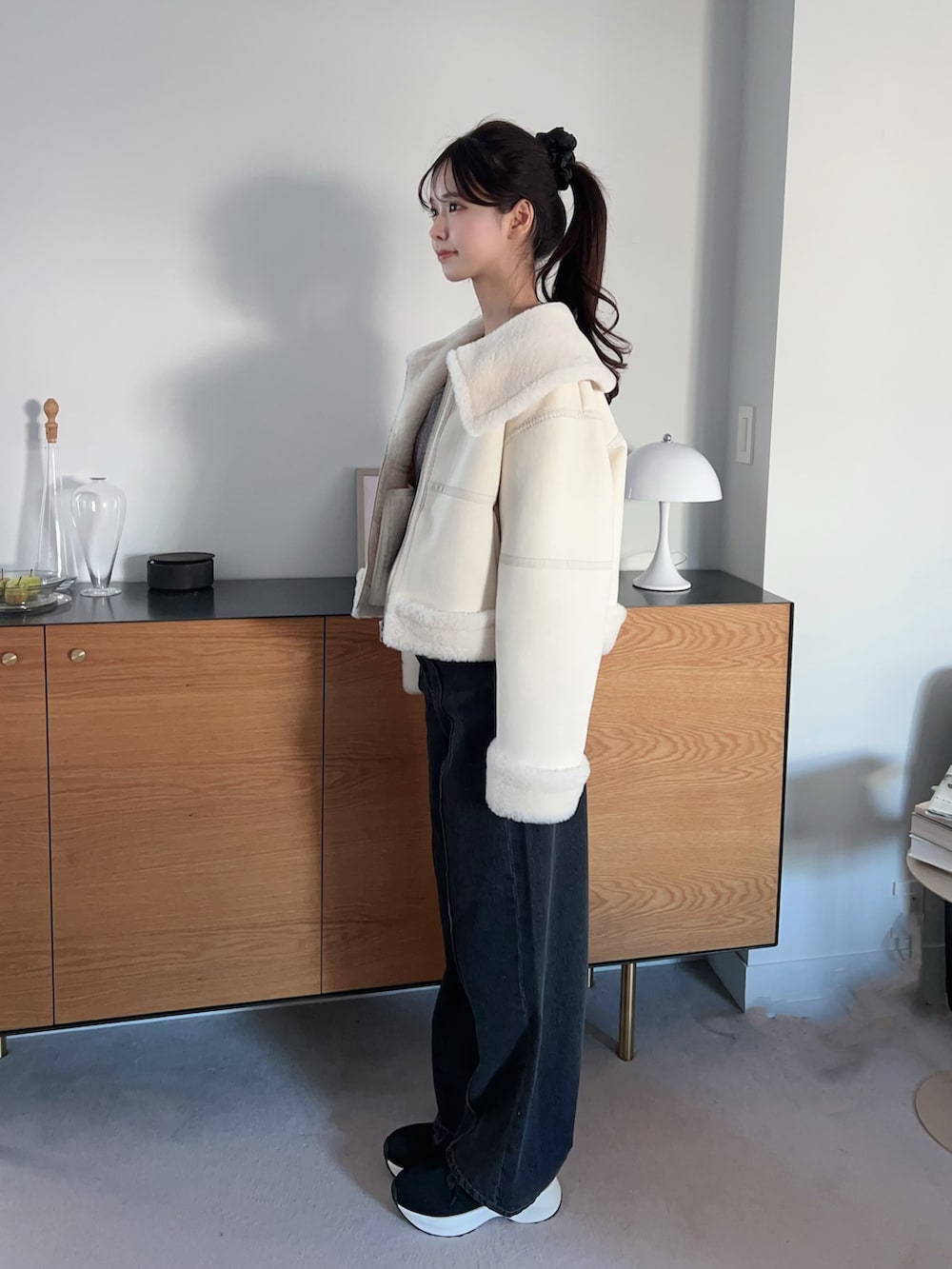 ホワイト系のブルゾン、ブラック系のブーツ、グレー系のTシャツ/カットソーを着用したレディースの冬コーディネートの3枚目の写真