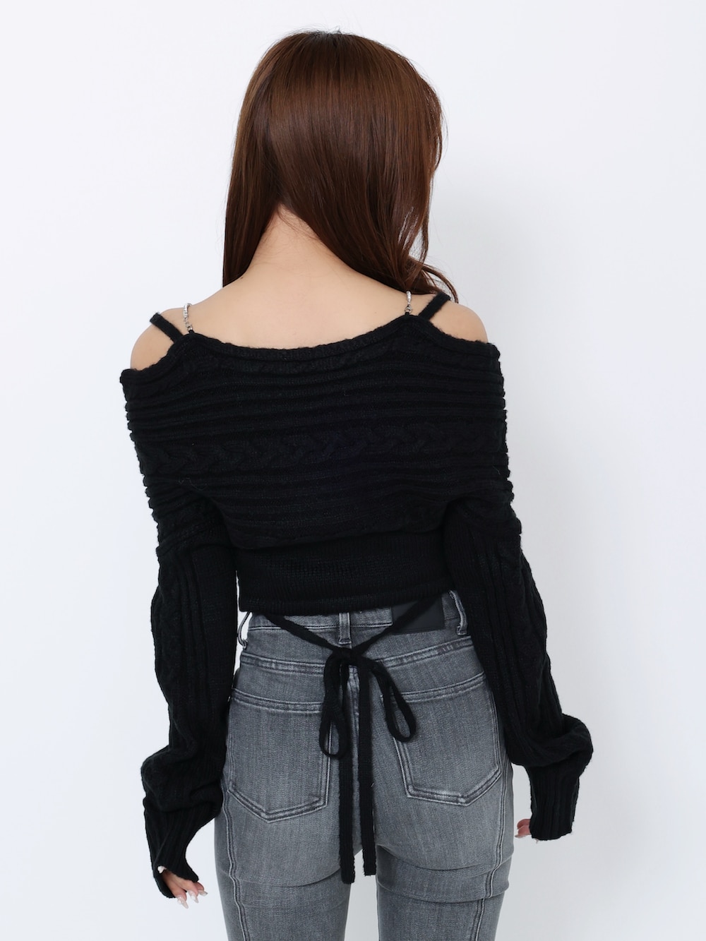 ブラック系のデニムパンツ、ブラック系のニット/セーター、ブラック系のブーツを着用したレディースの冬コーディネートの7枚目の写真