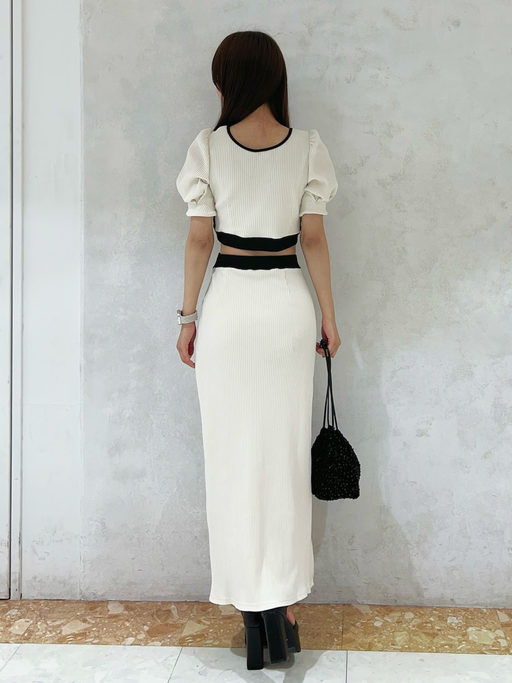 ホワイト系のTシャツ/カットソー、ホワイト系のスカート、ブラック系のハンドバッグを着用したレディースの夏コーディネートの3枚目の写真