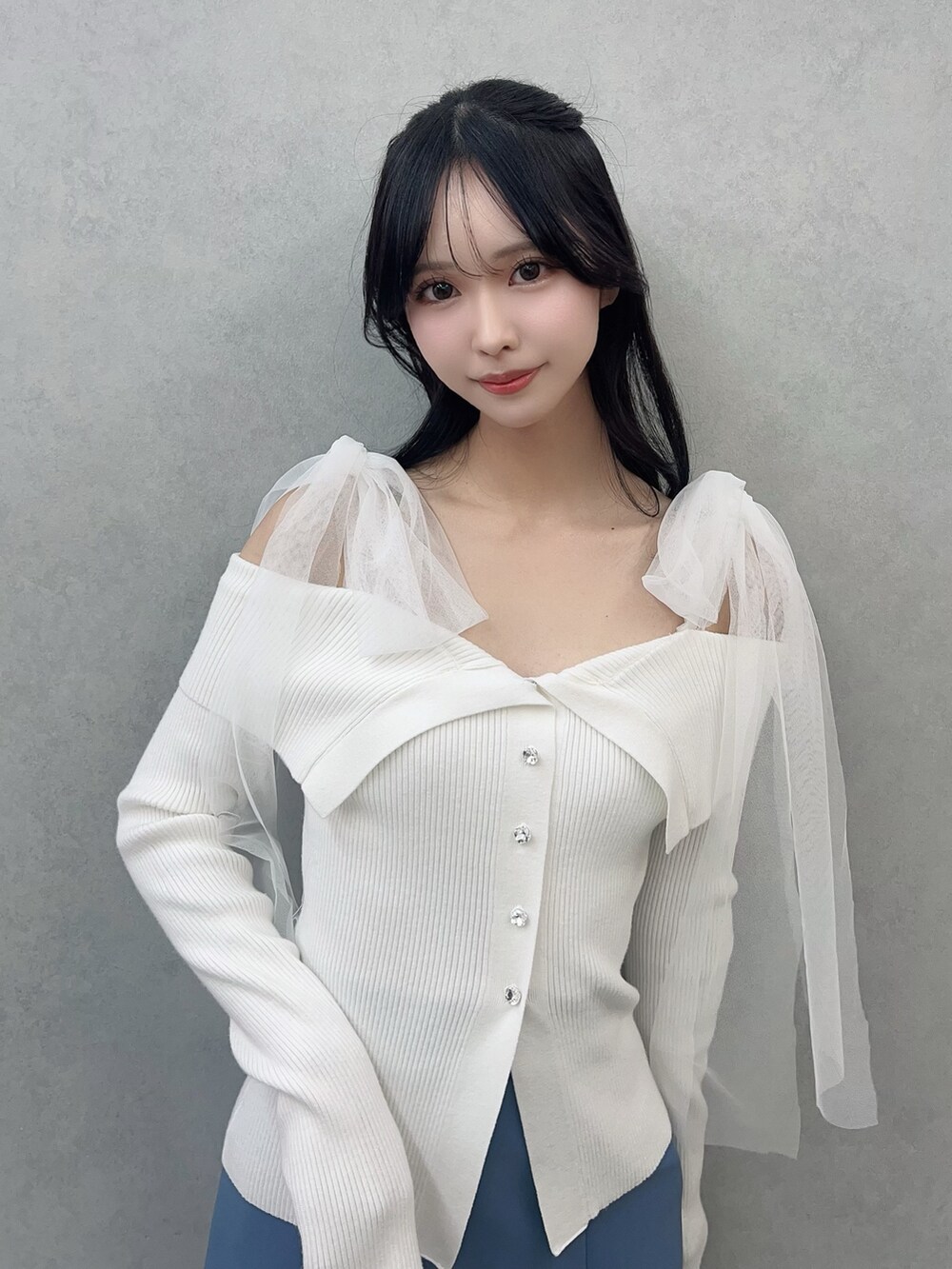 ホワイト系のニット/セーター、ブルー系のスカート、ホワイト系のブーツを着用したレディースの冬コーディネートの6枚目の写真