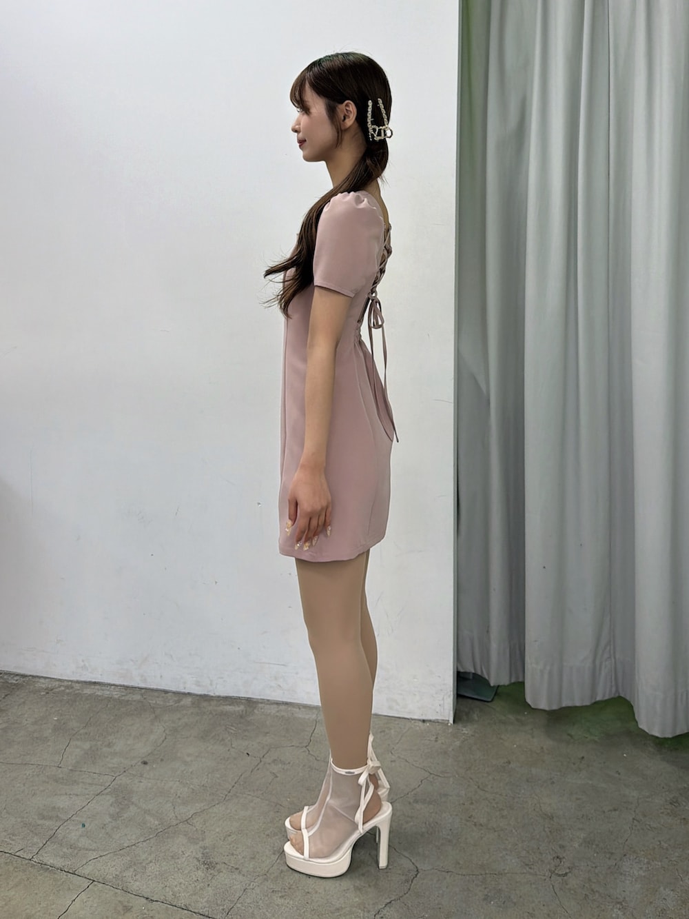 ピンク系のワンピース、ホワイト系のサンダル、ゴールド系のバレッタ/ヘアクリップを着用したレディースの春コーディネートの3枚目の写真