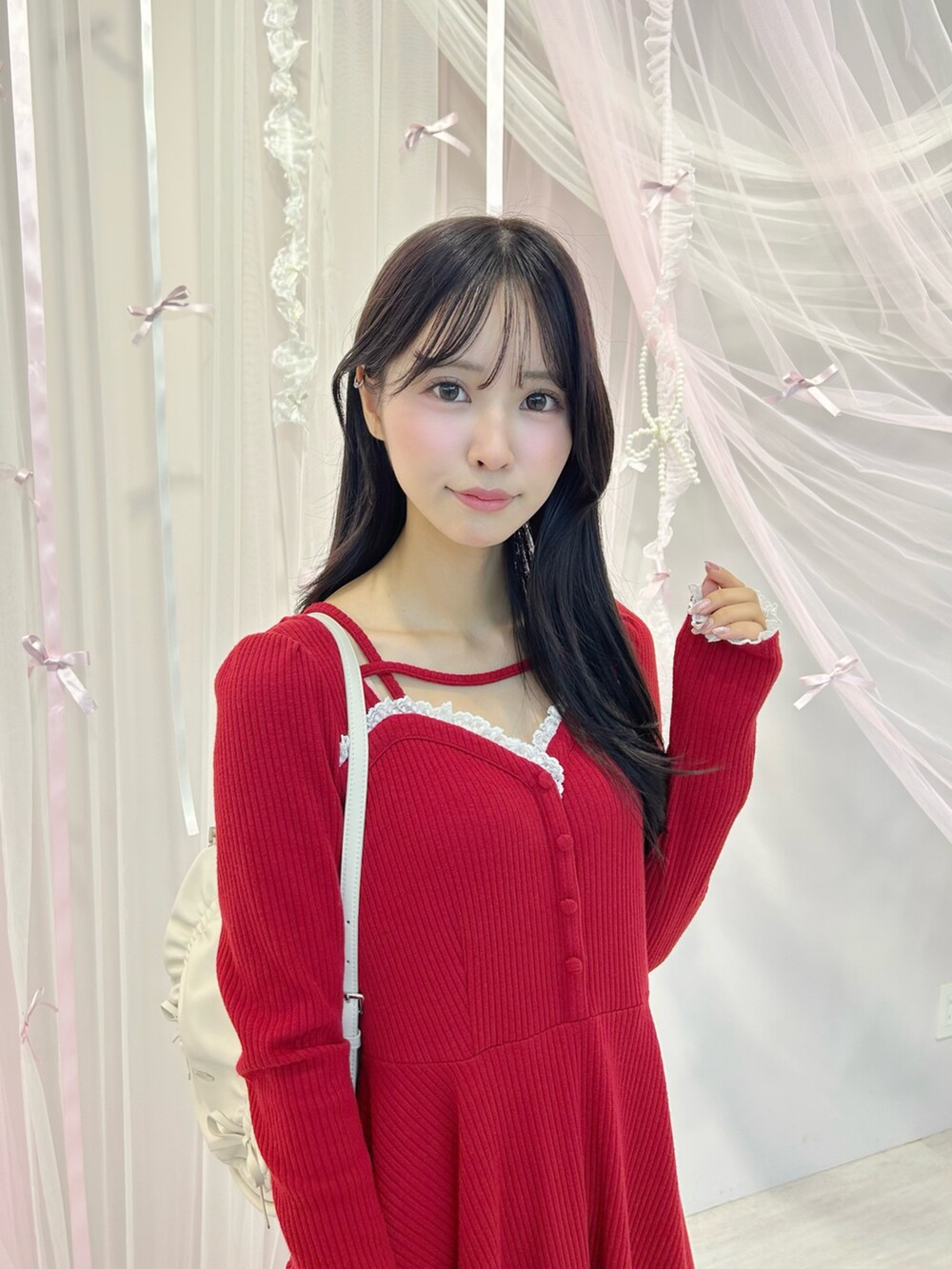 レッド系のワンピース、ホワイト系のショルダーバッグ、ブラック系のパンプスを着用したレディースの冬コーディネートの4枚目の写真