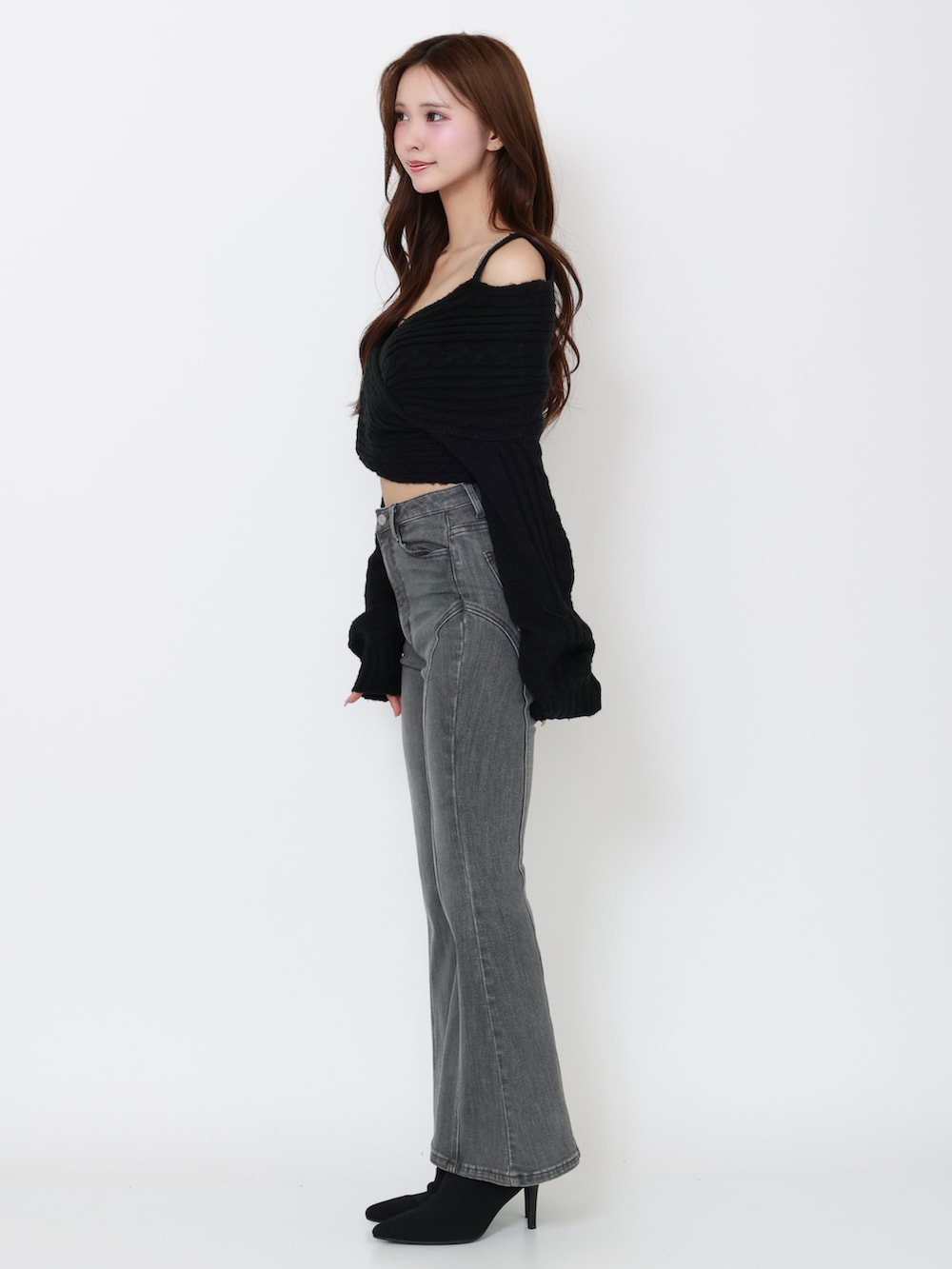 ブラック系のデニムパンツ、ブラック系のニット/セーター、ブラック系のブーツを着用したレディースの冬コーディネートの3枚目の写真