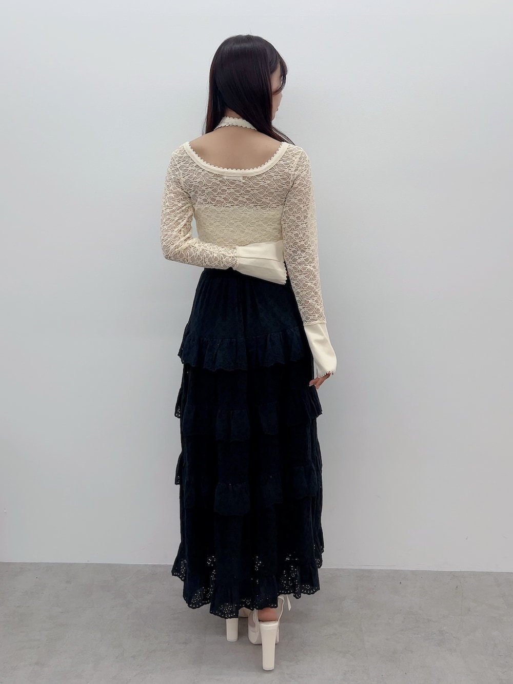 イエロー系のTシャツ/カットソー、ブラック系のスカート、ホワイト系のサンダルを着用したレディースの春コーディネートの4枚目の写真