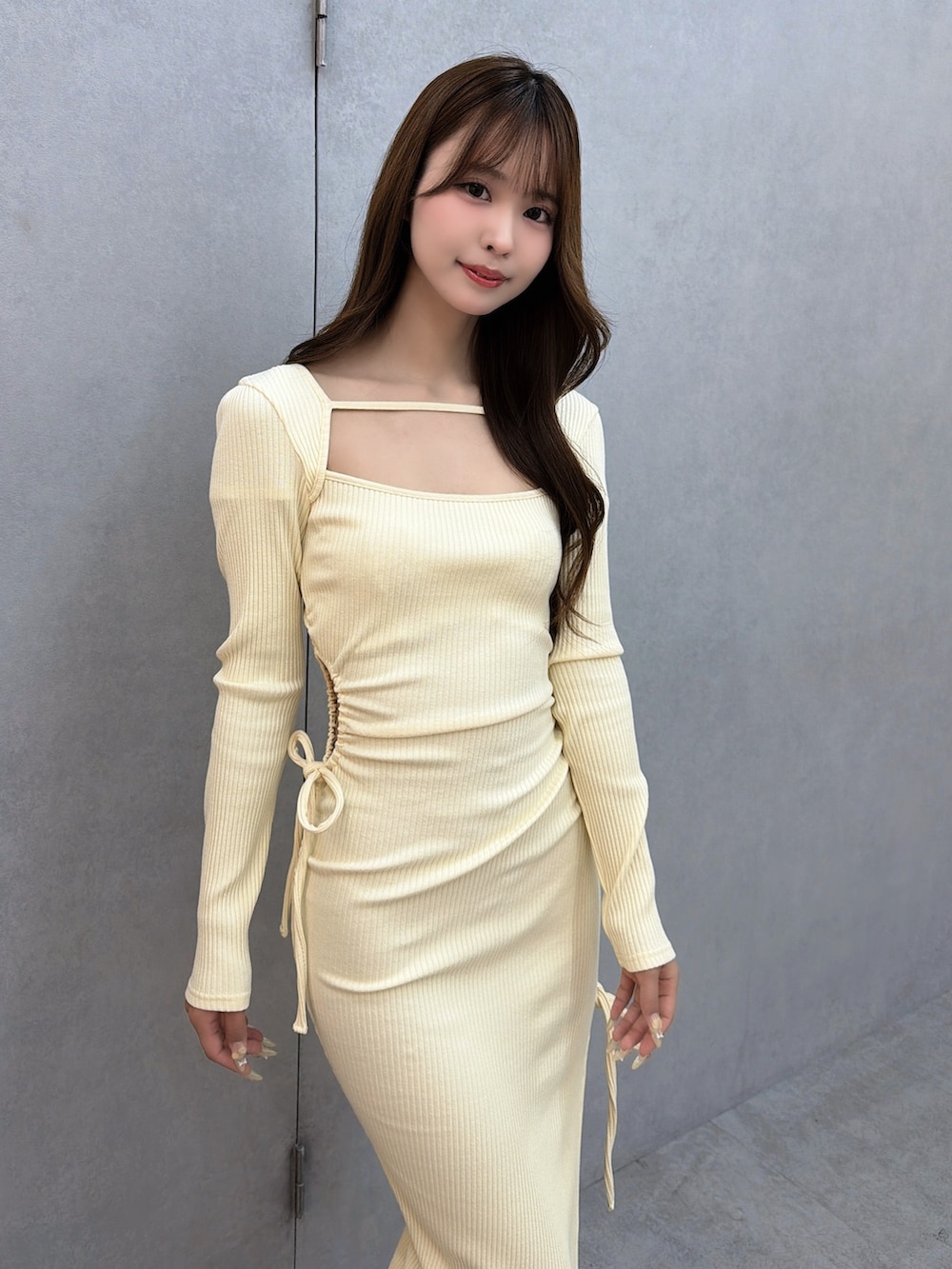 イエロー系のワンピース、ホワイト系のサンダルを着用したレディースの冬コーディネートの7枚目の写真