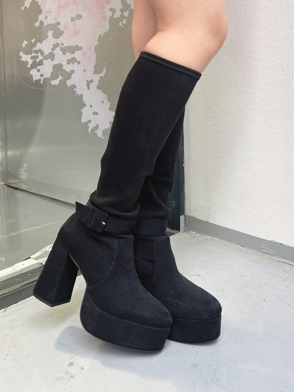 ブラック系のワンピース、ホワイト系のハンドバッグ、ブラック系のブーツを着用したレディースの秋コーディネートの8枚目の写真